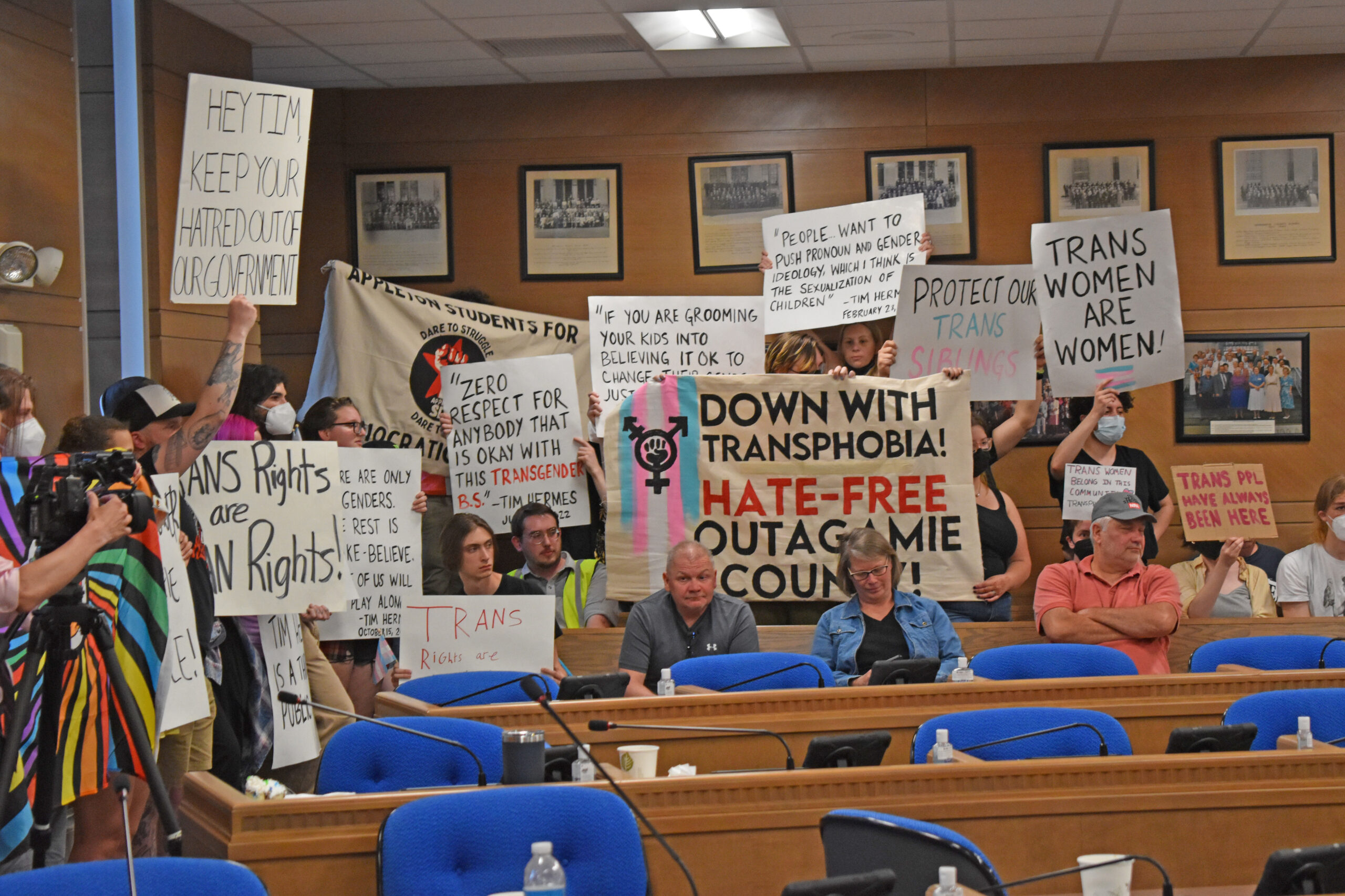 Protesters rally inside the Outagamie County Board room Tuesday night