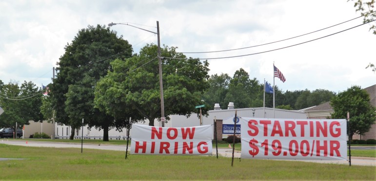 Signs along Charles Street in Oconto, Wis. advertise job openings at LeTourneau Plastics.