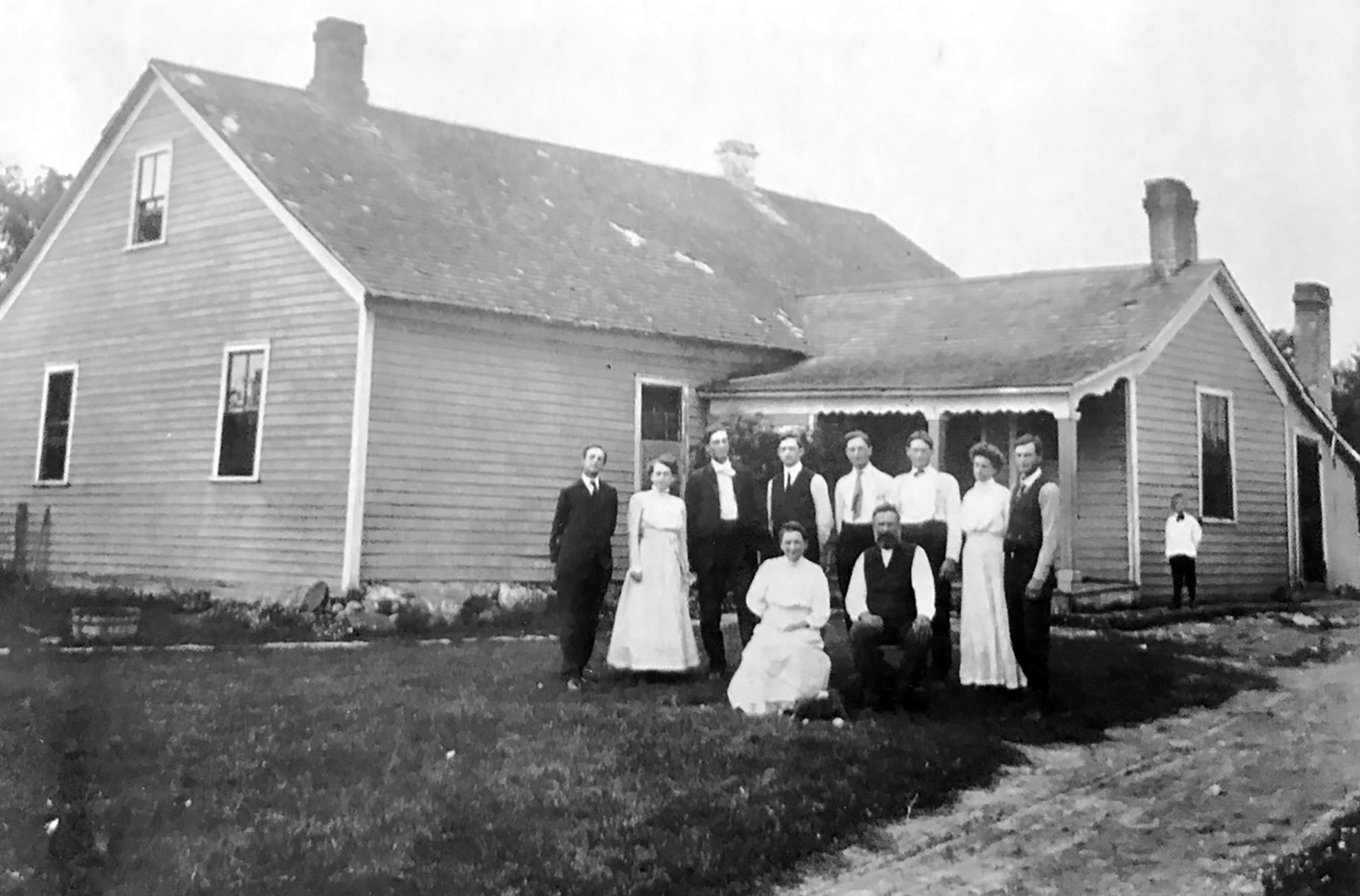 The John Klug family, German immigrants in front of their 1800s home.