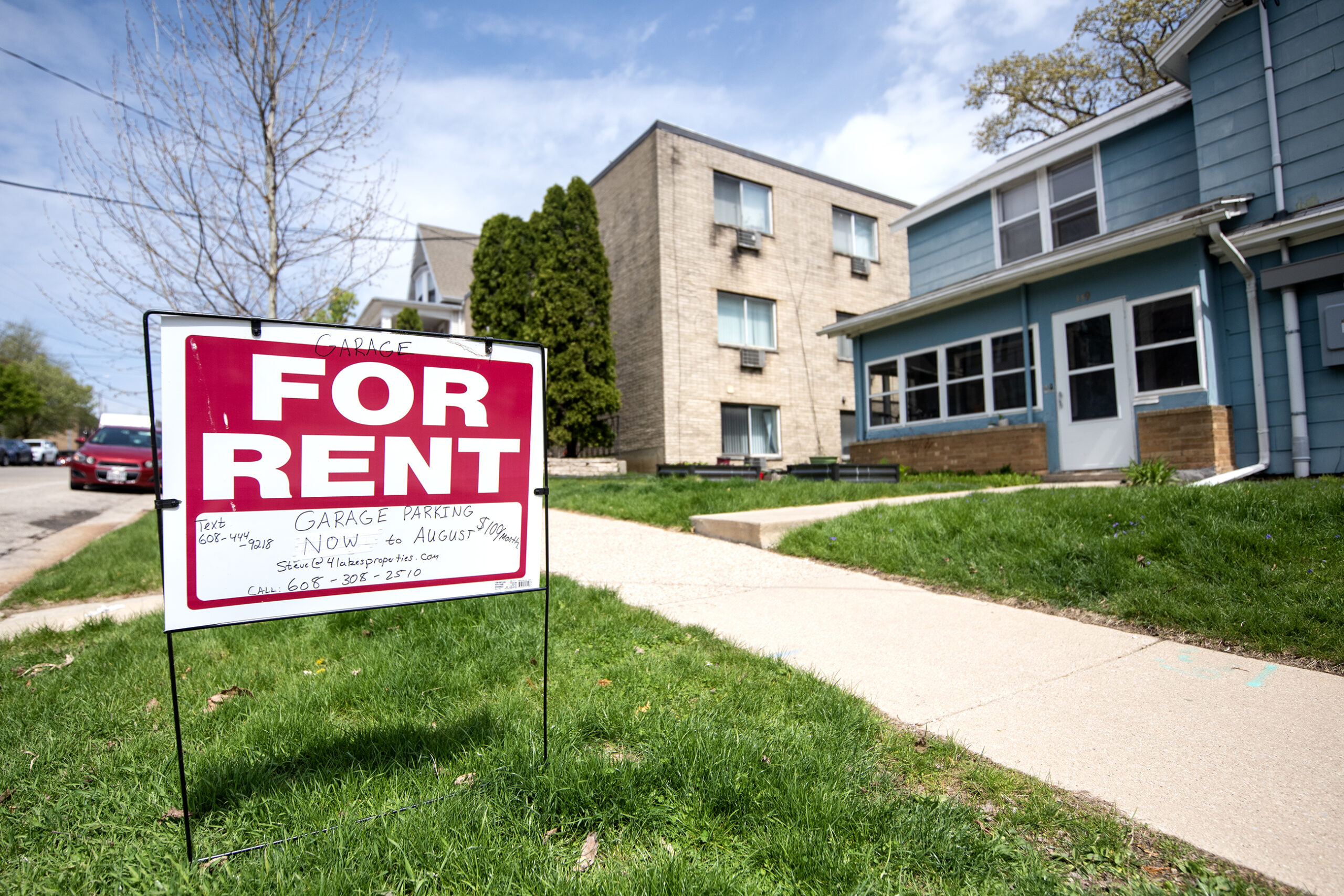 A lawn sign says "FOR RENT" with apartment details listed.