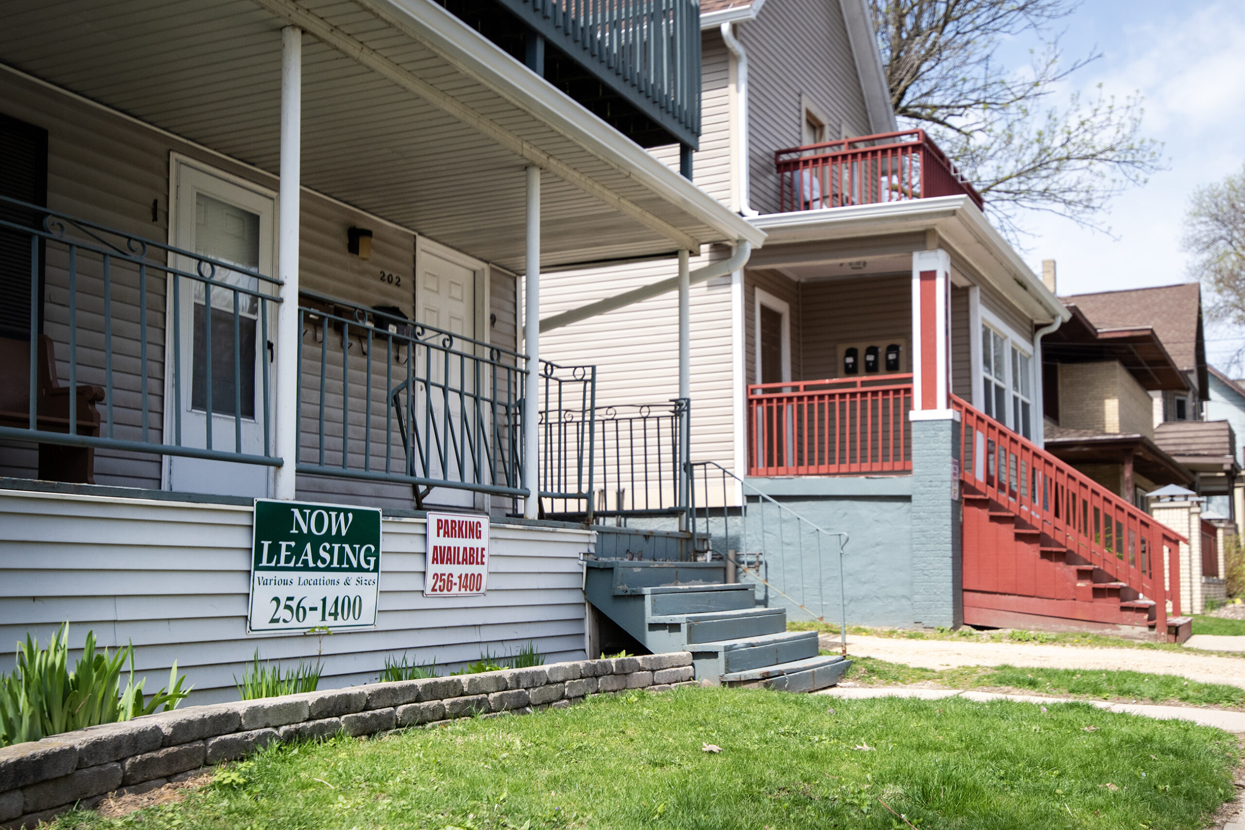 Two signs are posted on a porch advertising spaces for rent.