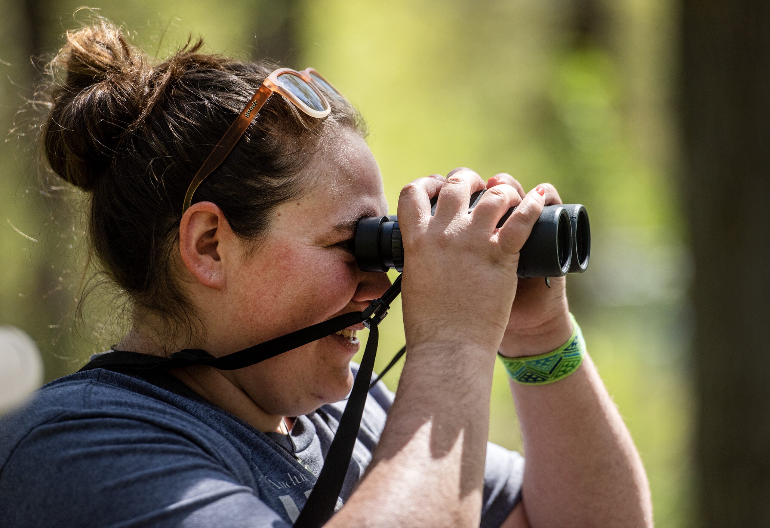 A woman looks through binoculars.