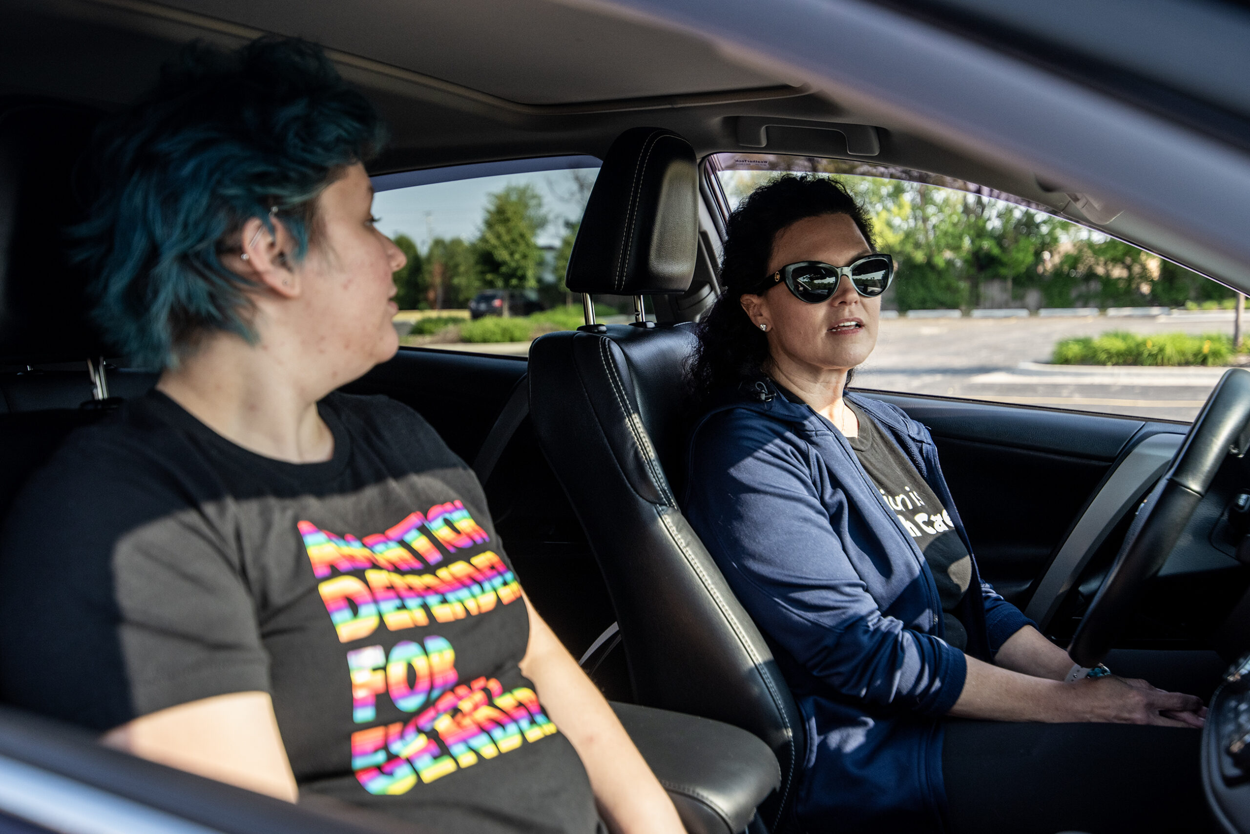 Two people sit in a car.