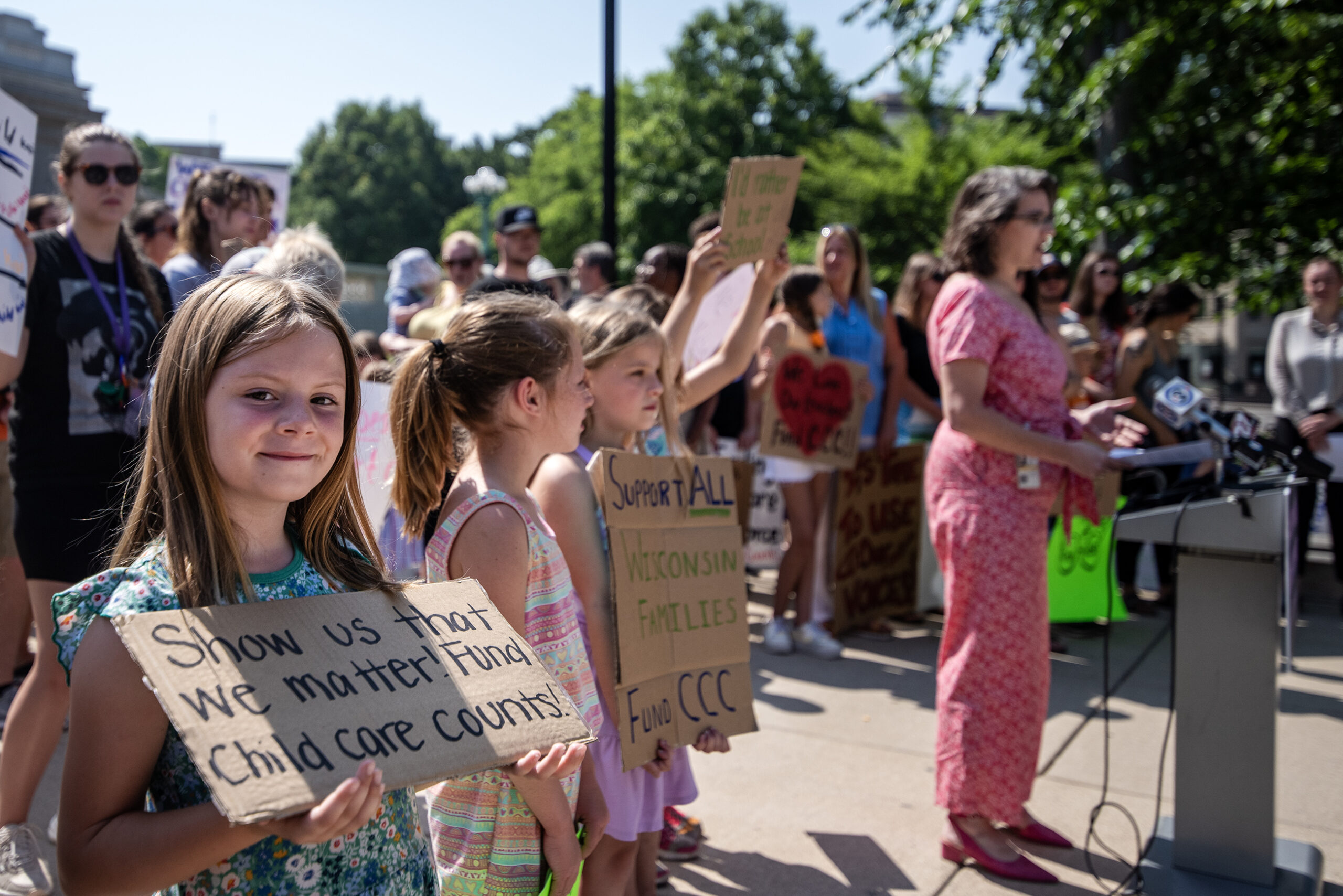 A child holds a sign that says 