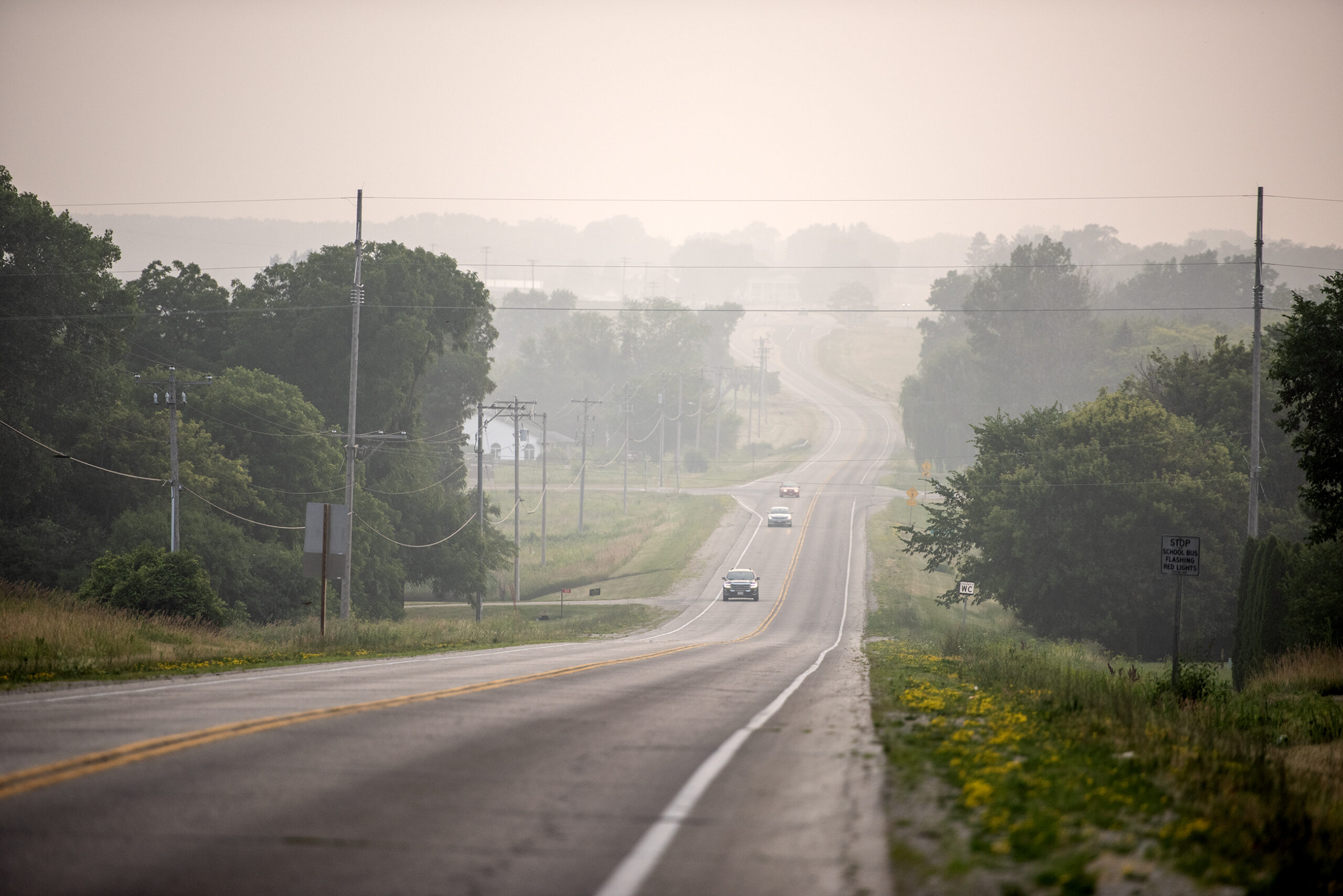 A view down a highway showing white smoke clouding the air.