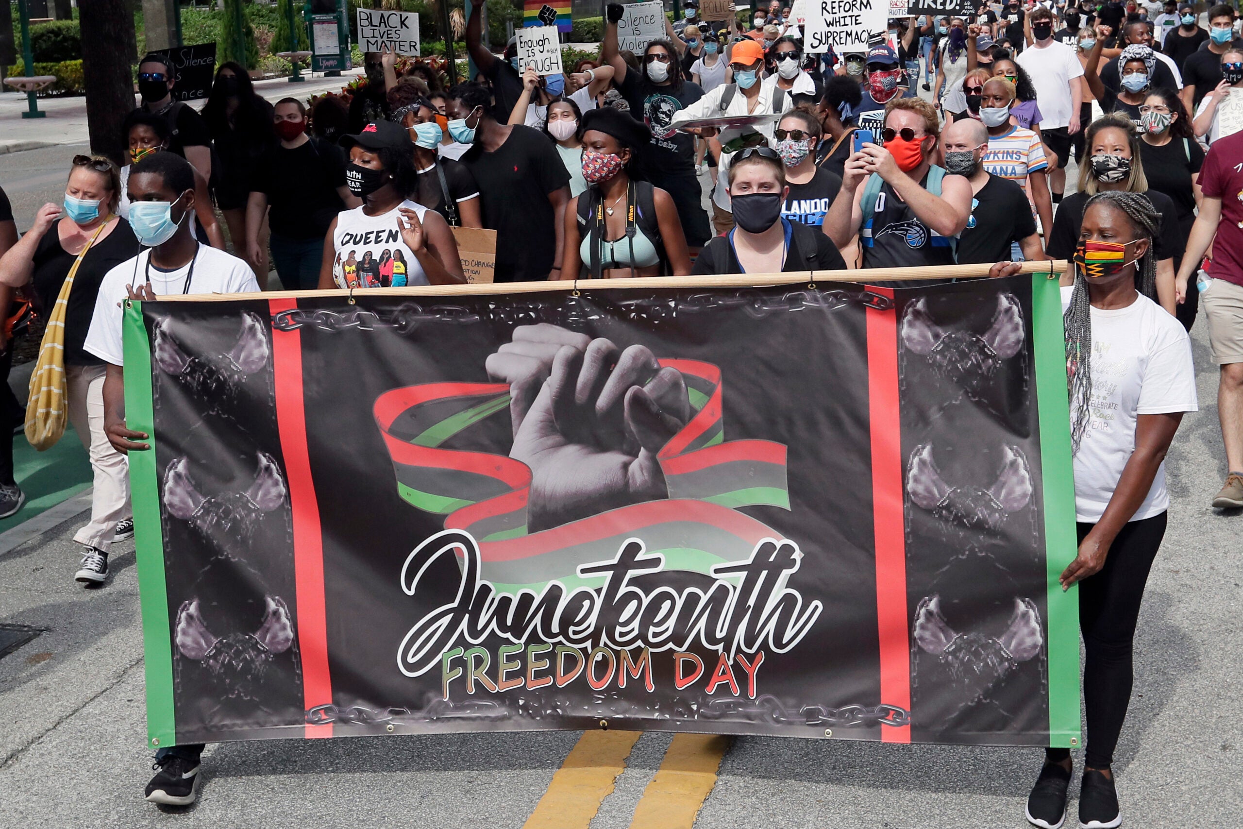 demonstrators march through downtown Orlando, Fla., during a Juneteenth event