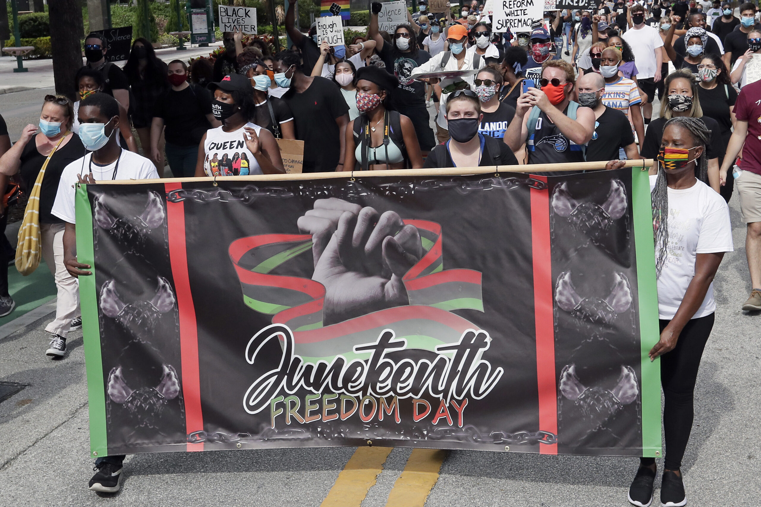 demonstrators march through downtown Orlando, Fla., during a Juneteenth event