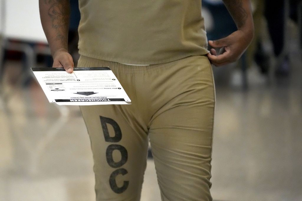 An inmates at the Cook County, Ill., jail takes his covered ballot to be cast at the jail's Division 11 Chapel after voting in a local election on Saturday, Feb. 18, 2023, in Chicago. (AP Photo/Charles Rex Arbogast)