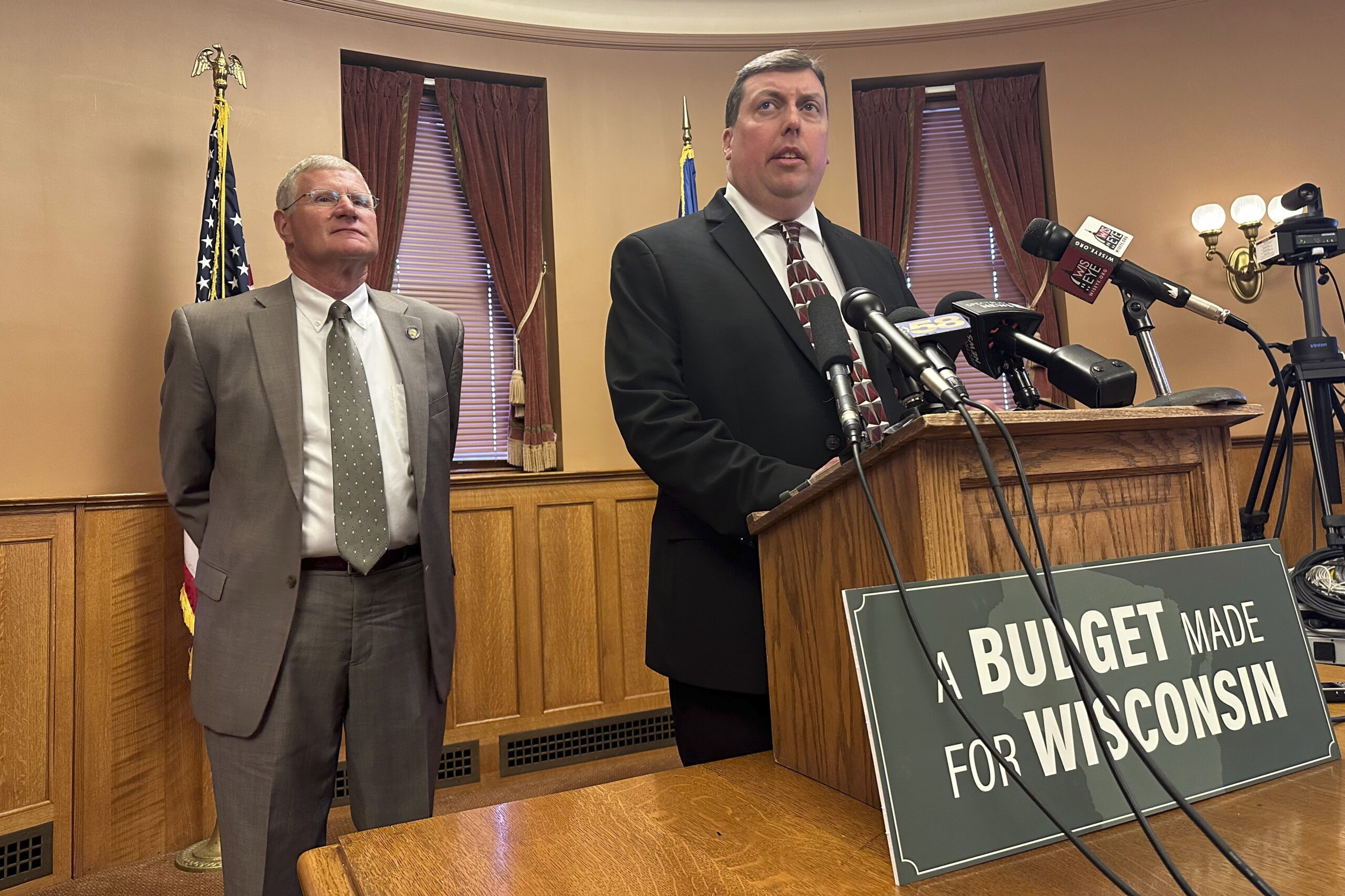 Legislators standing at a podium during a press conference