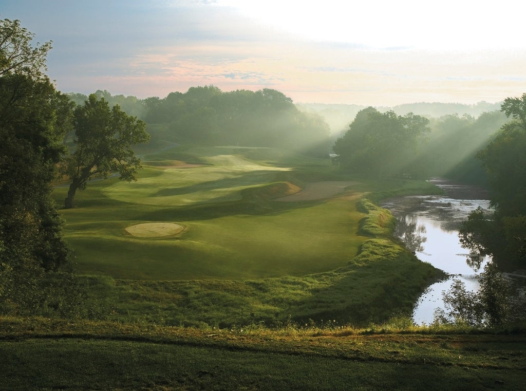 A light fog hovers over the green of a golf course.