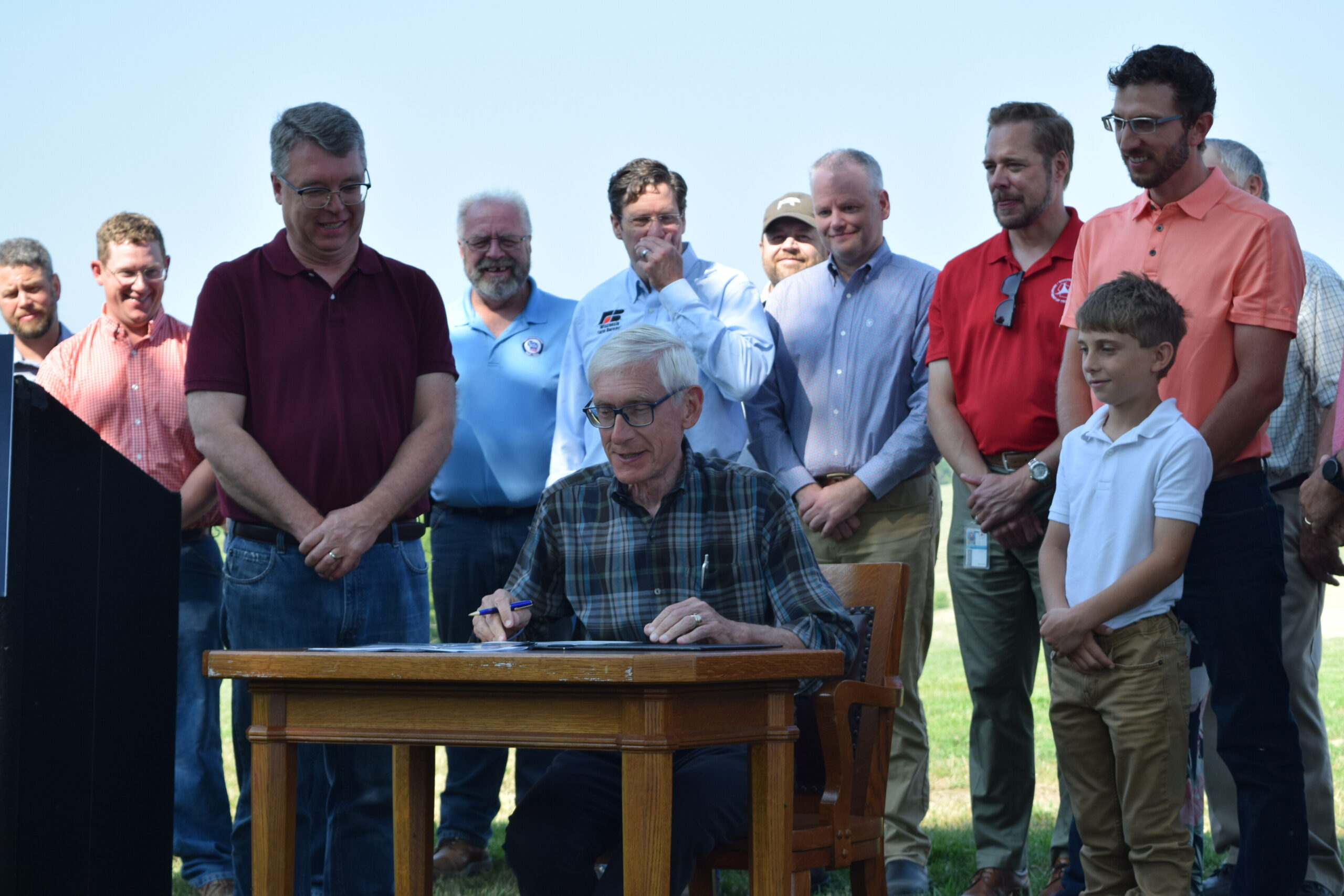 Evers signs a bill surrounded by state lawmakers and farm advocates