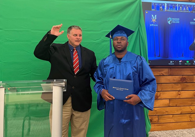 Jimmy Cunningham stands with a member of the Second Chance program to receive his degree