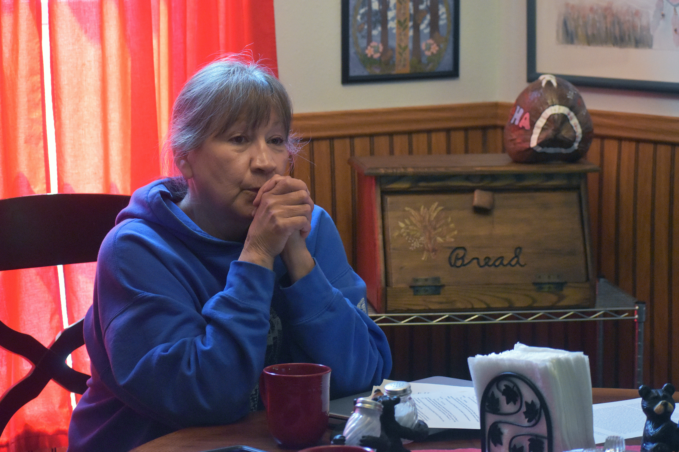 Sandy Deragon sits at her table