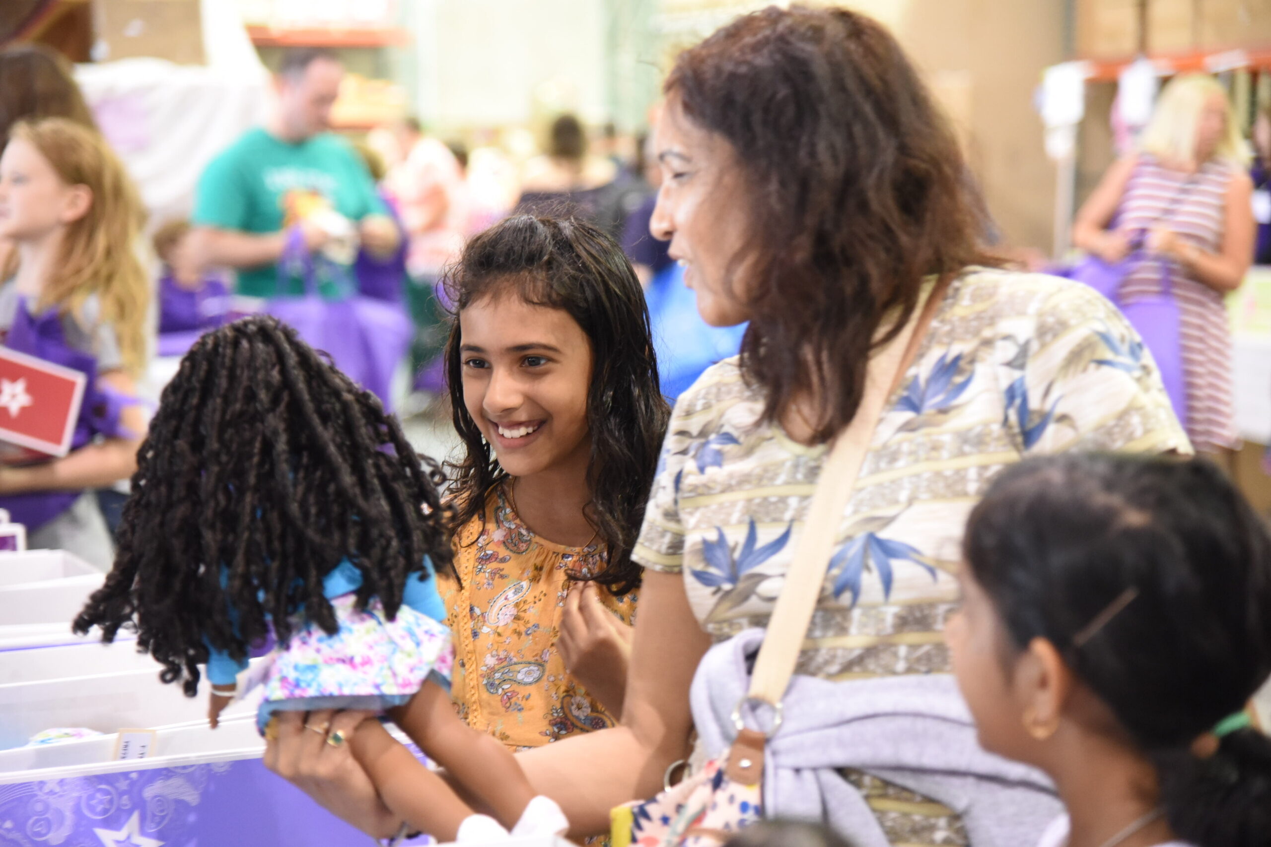 Shoppers in 2018 inspect dolls that are donated by the American Girl.