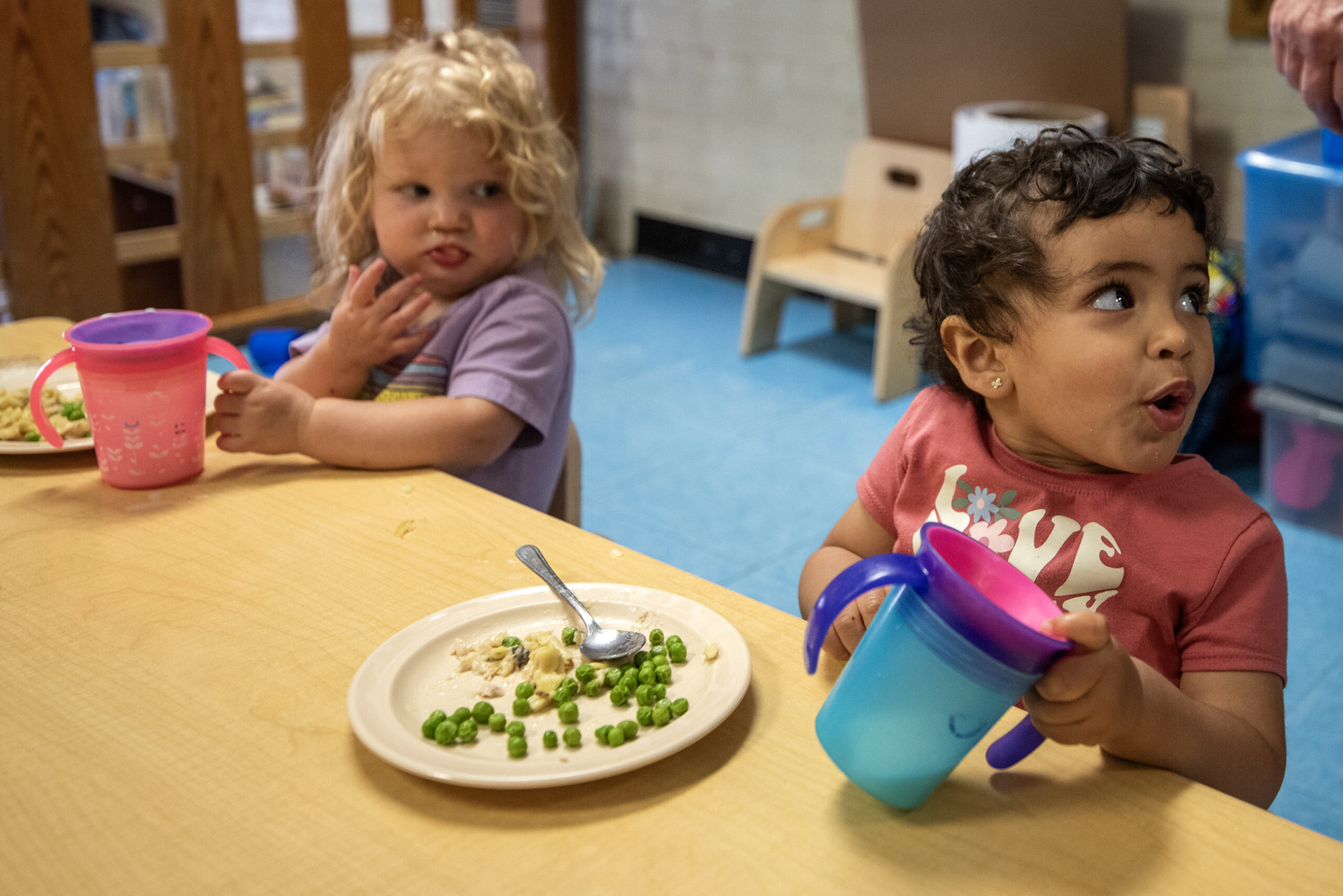 Two children eat lunch at a table.