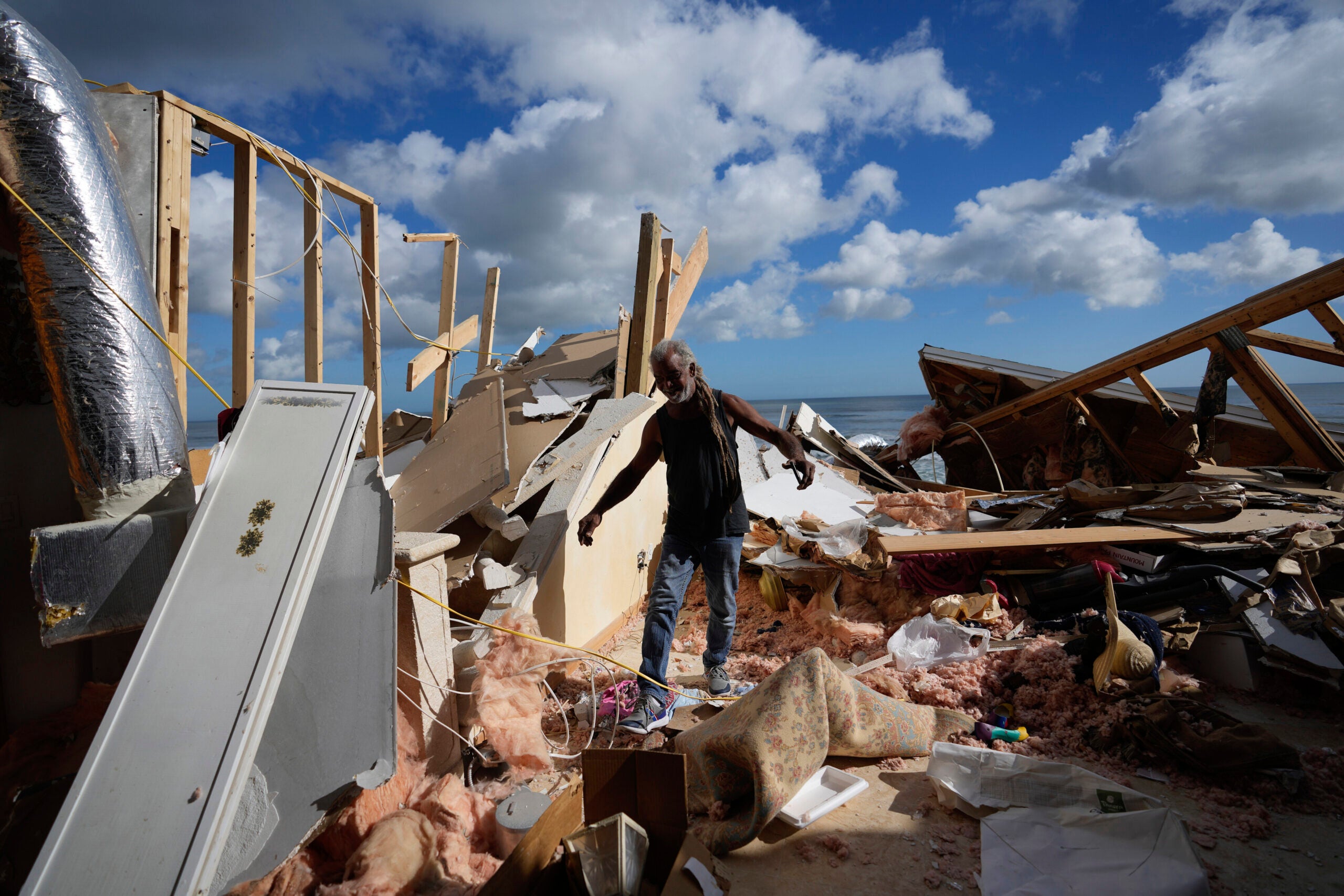 A person walking through wreckage of a hurricane