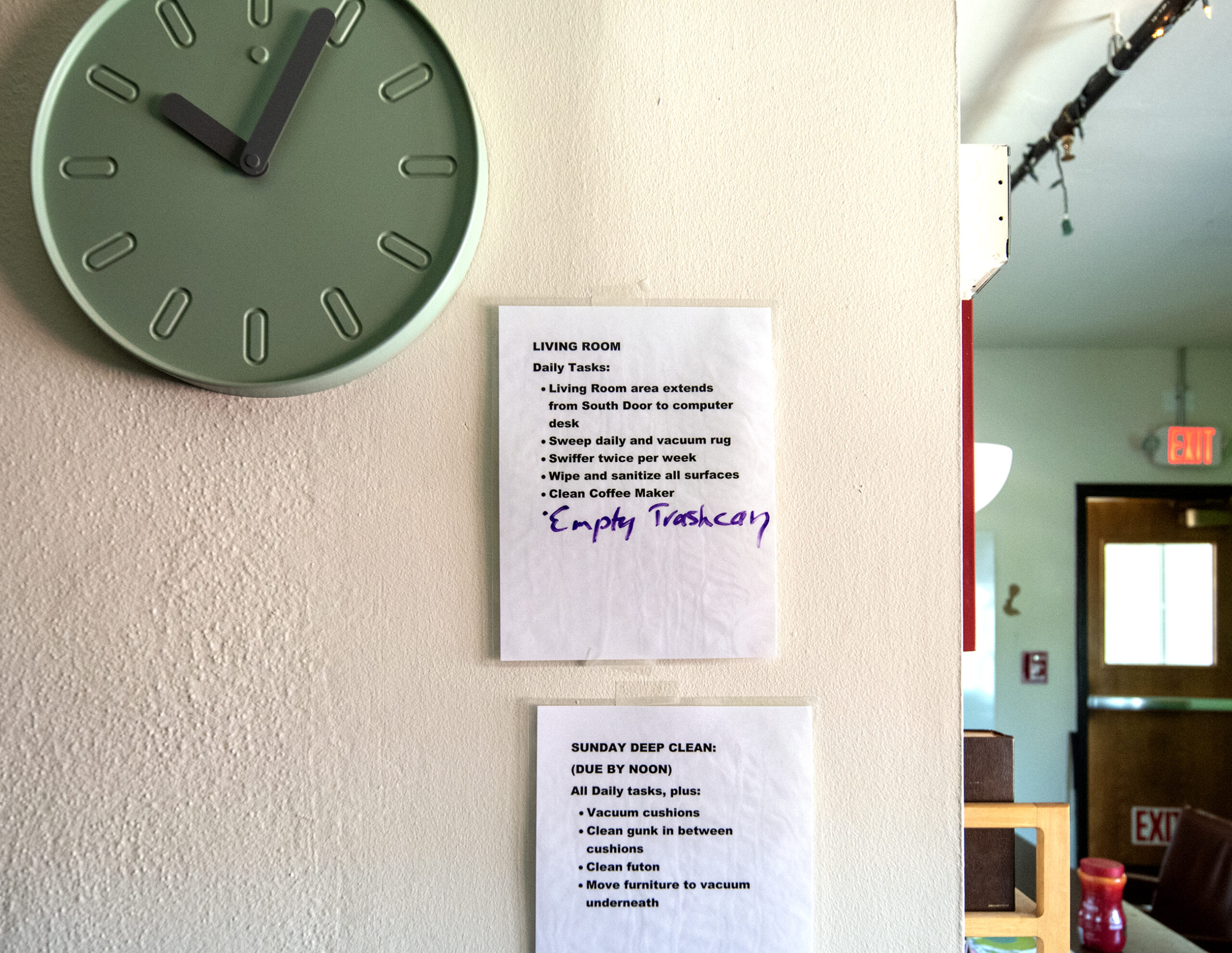Lists with cleaning tasks listed on them are hung on the wall.