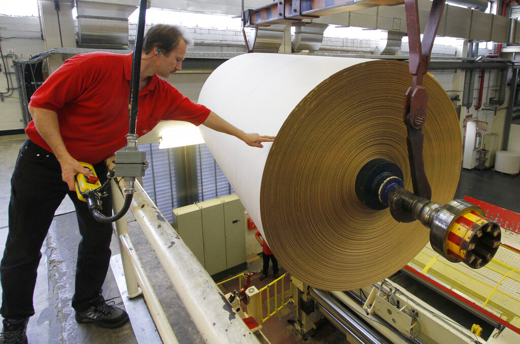 A worker of the paper production at the Melitta household products factory in Minden, northern Germany, handles a paper roll of about 18000 meters of filter paper on Thursday, Nov. 4, 2009. Focke Strangmann/AP Photo
