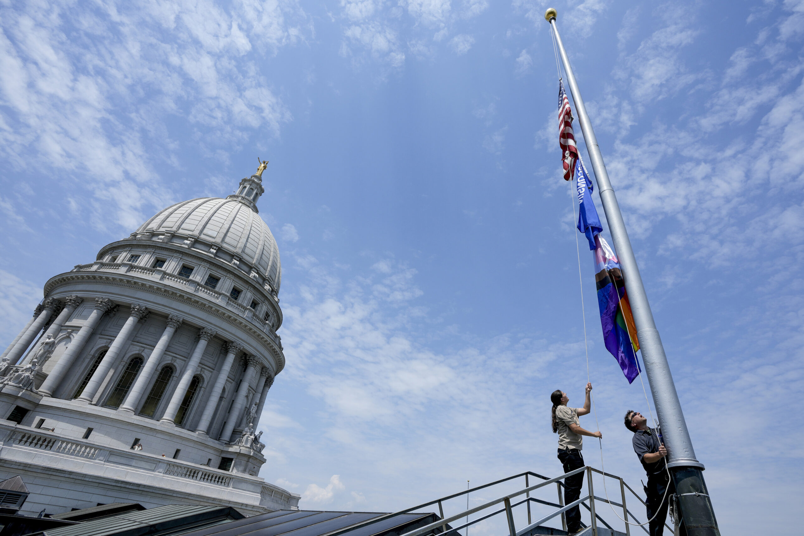 Mindy Fude and Steve Walker raise the Pride Flag at the state Capitol.