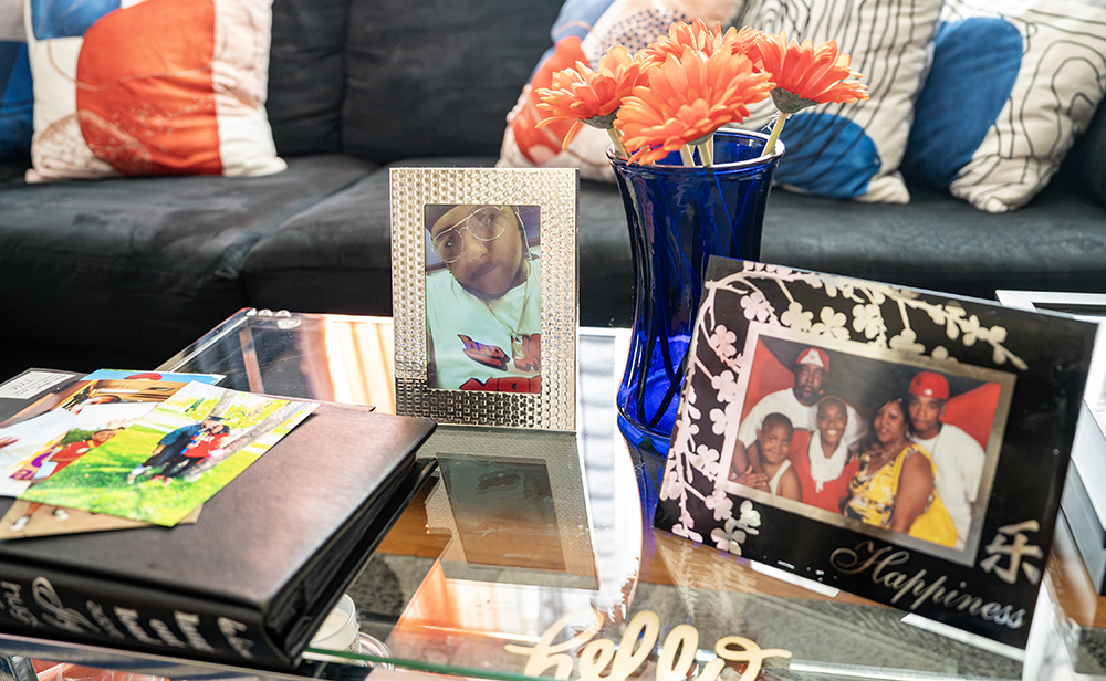 Photos of Le’Quon McCoy rest on the coffee table at Antoinette Broomfield’s apartment in Milwaukee on July 25, 2023