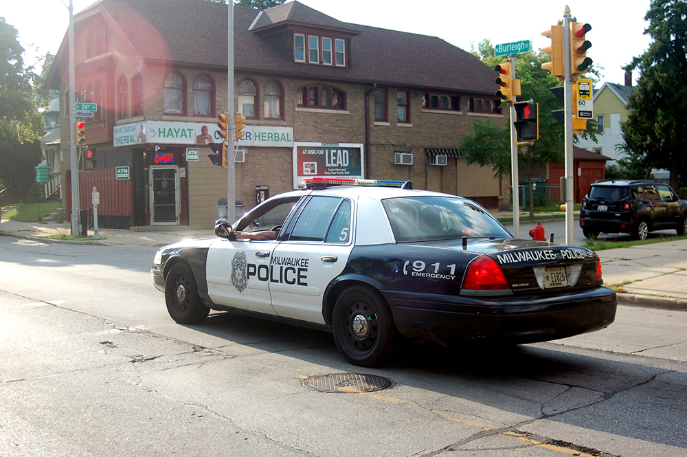 a police cruiser drives in the Amani neighborhood on Milwaukee's North Side in 2018