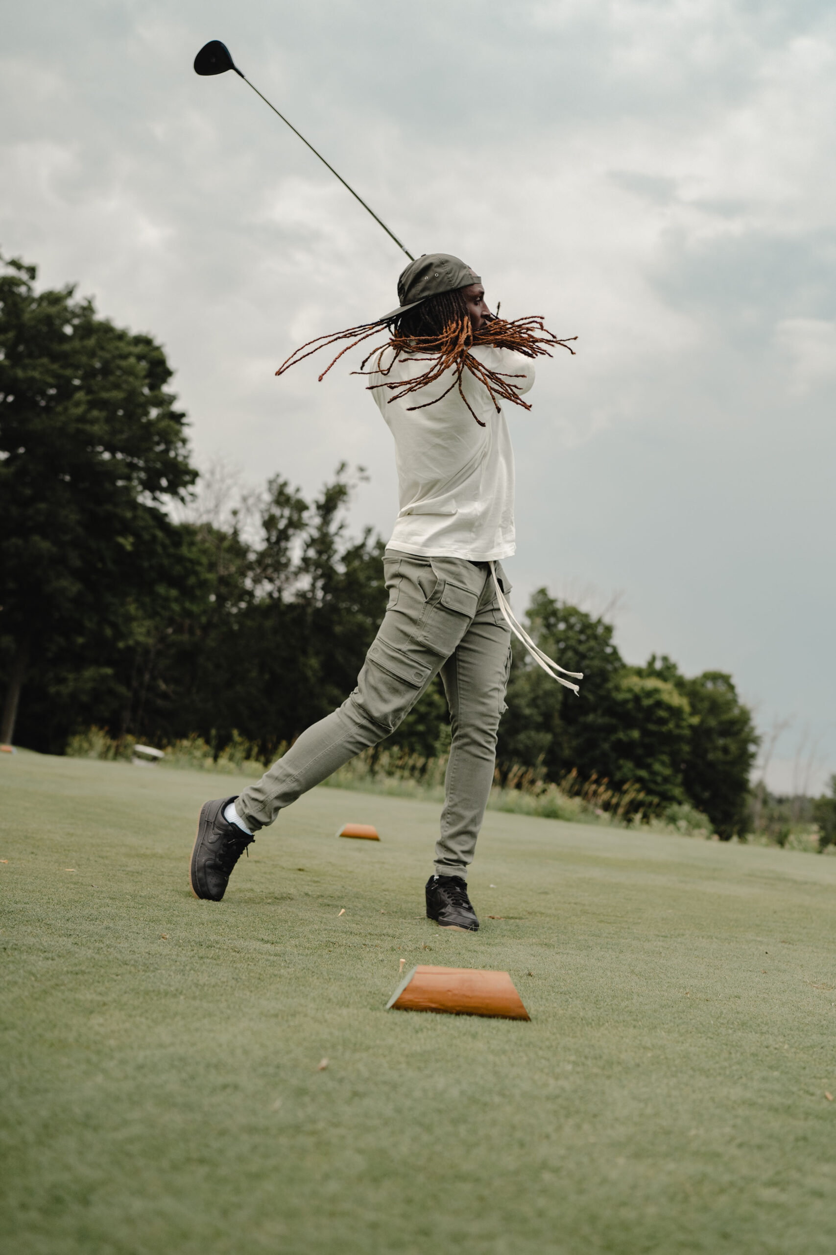 A former Badgers football player swings a golf club during a tournament