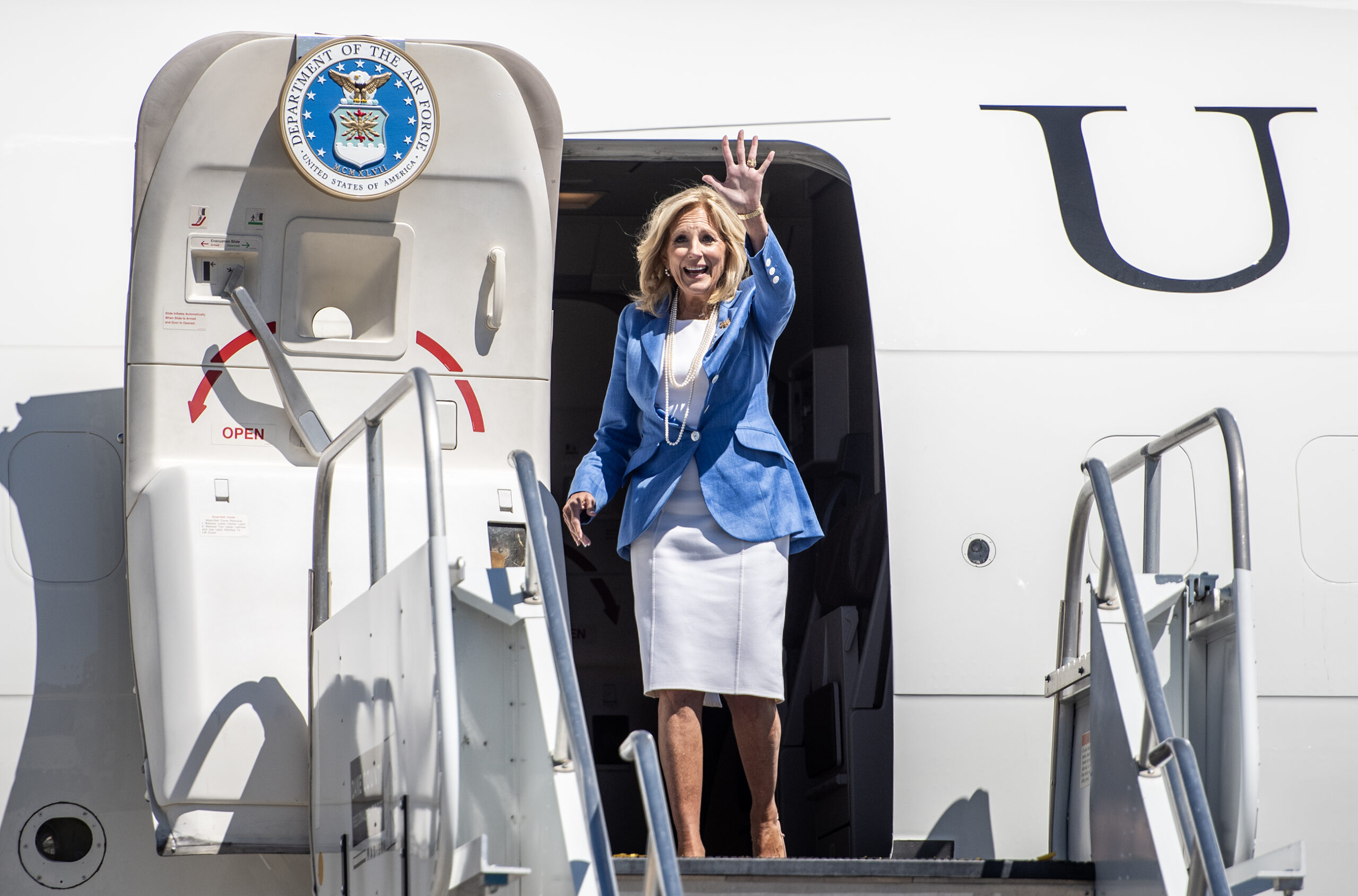 Jill Biden waves as she steps out of her plane.