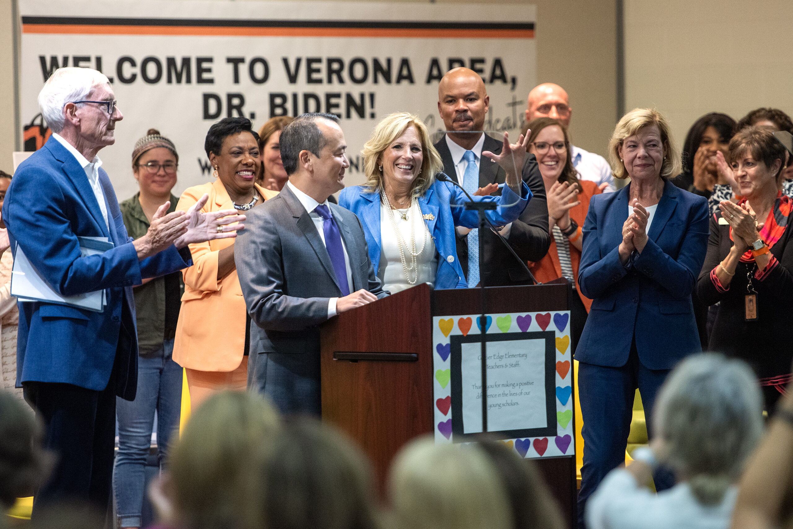 A sign behind Jill Biden and the rest of the people on stage says 