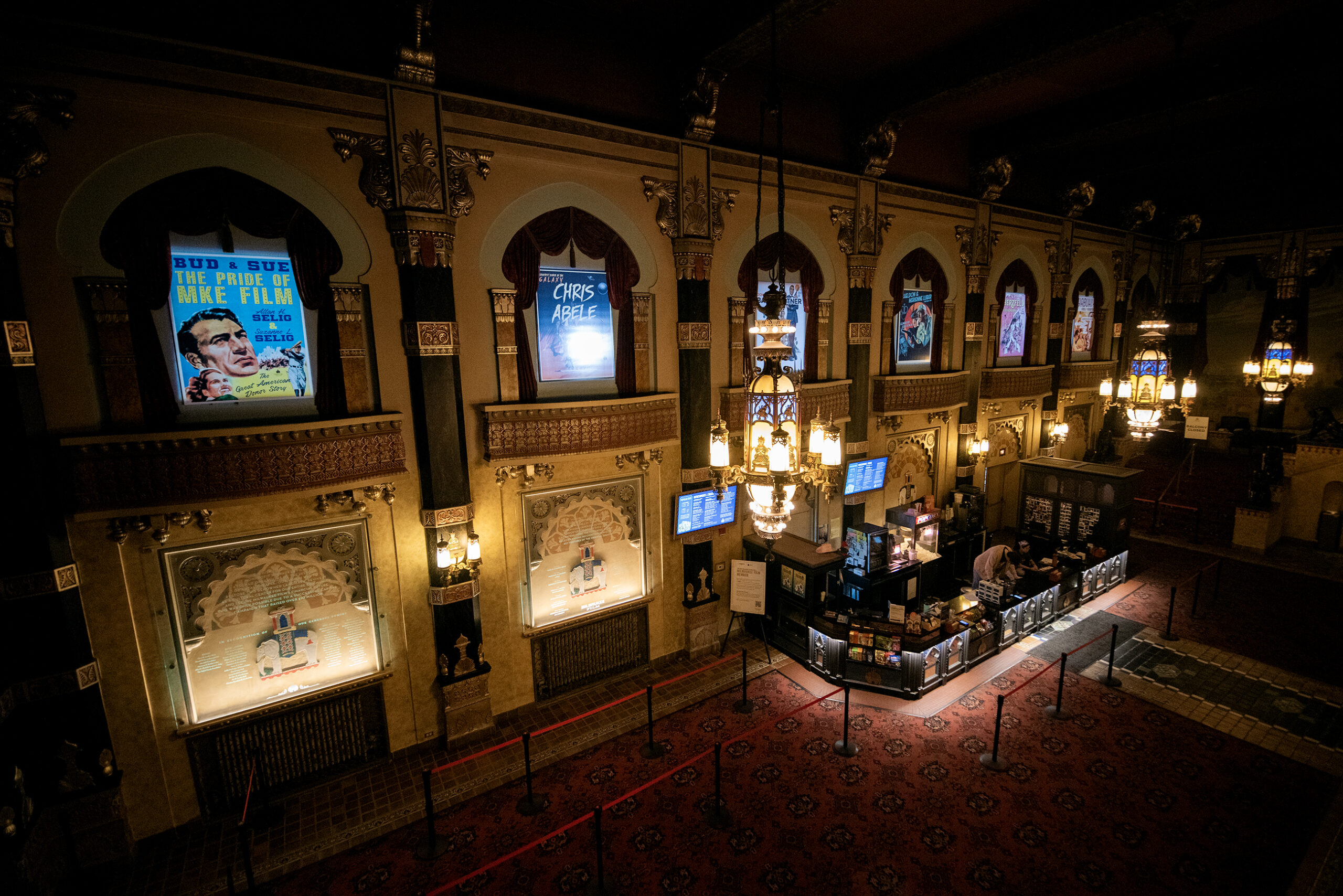 A movie theater lobby has ornate decoration.