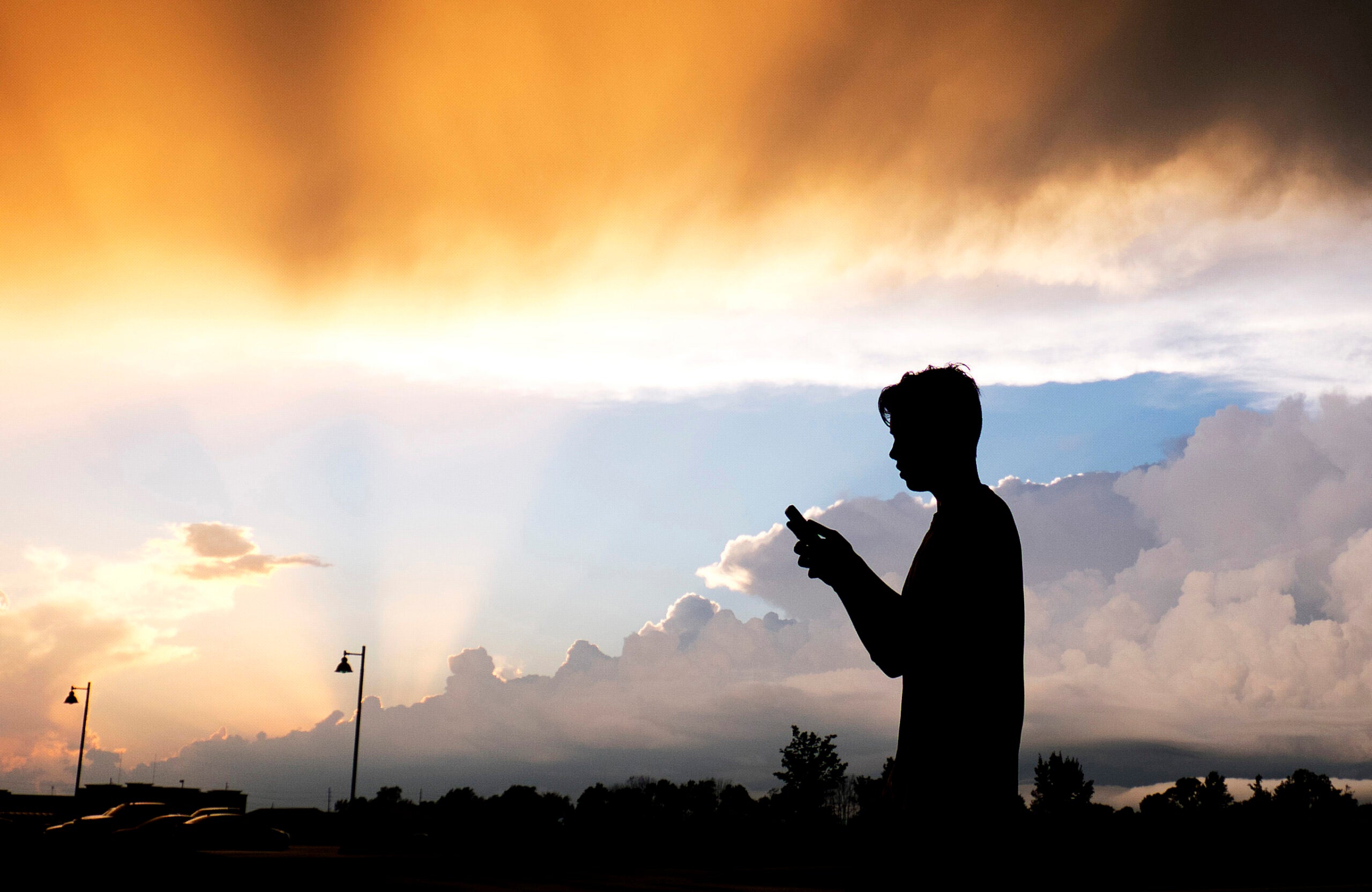 A teenager checks his cell phone.