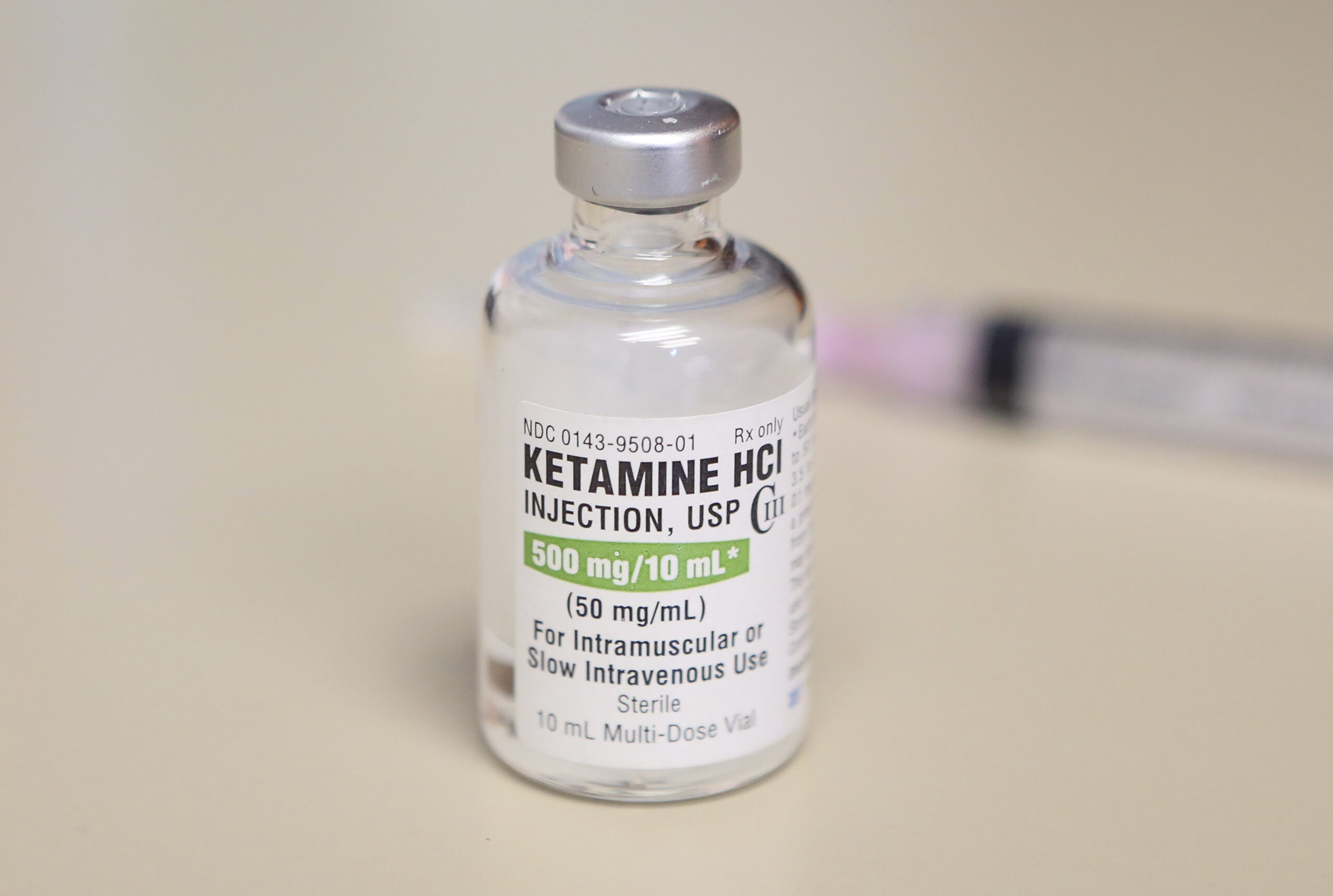 A vial of ketamine sits on a table