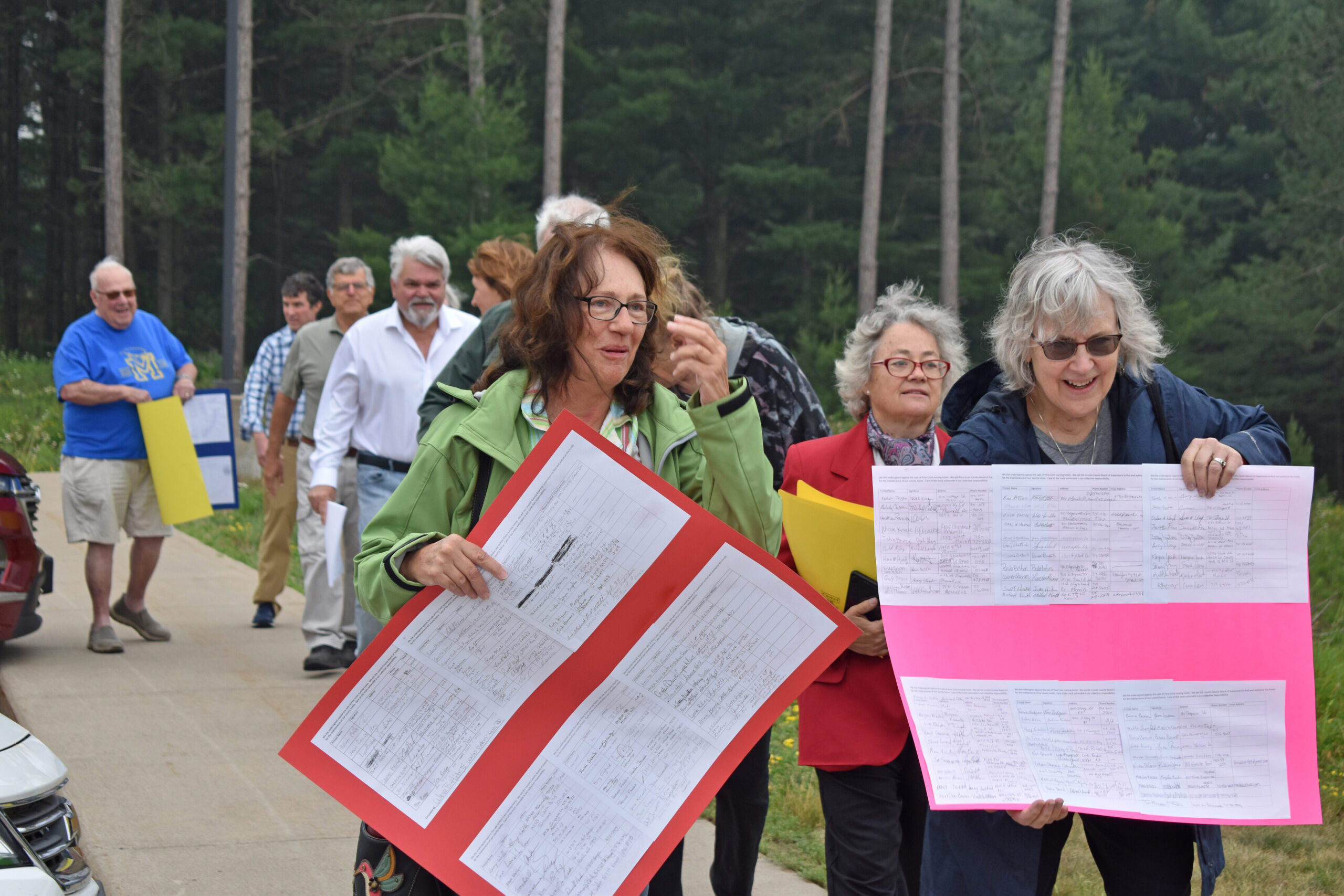 Community members march into a Lincoln County building to protest the possible sale of Pine Crest Nursing Home