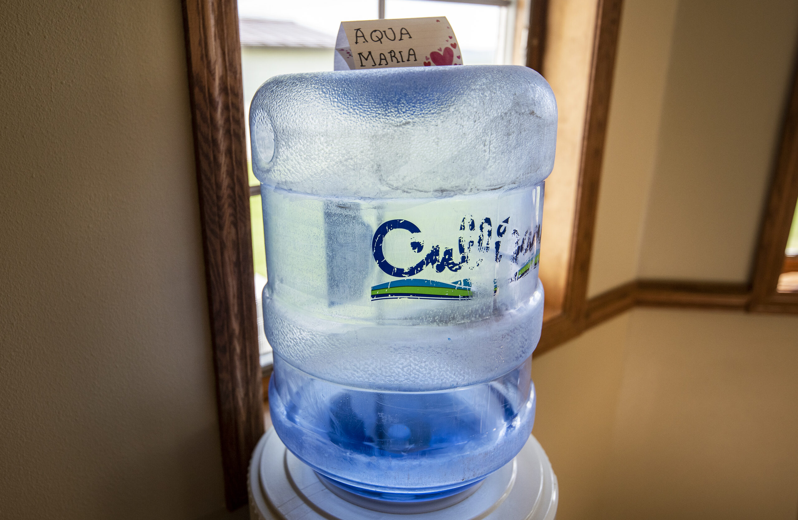 A Culligan jug has a homemade sign that says "Aqua Maria" on top of it.
