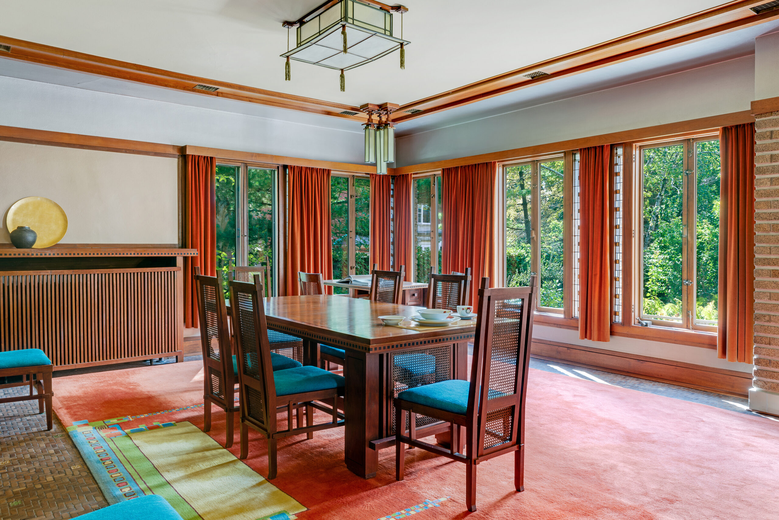 A dining room table and chairs are in a room with many windows.