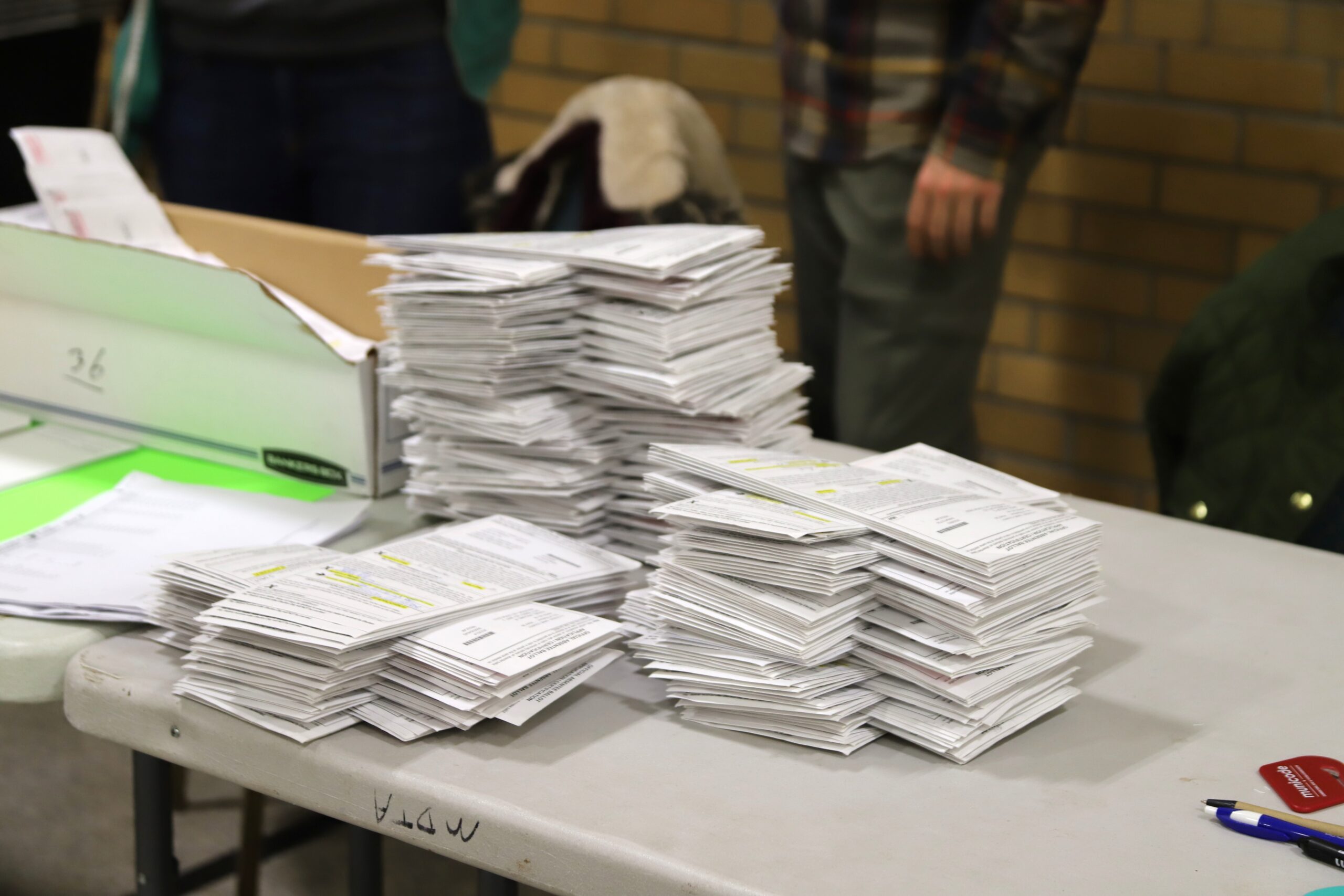 Stacks of absentee ballots wait to be counted at Mendota Elementary School on Madison's north side on Nov. 3, 2020