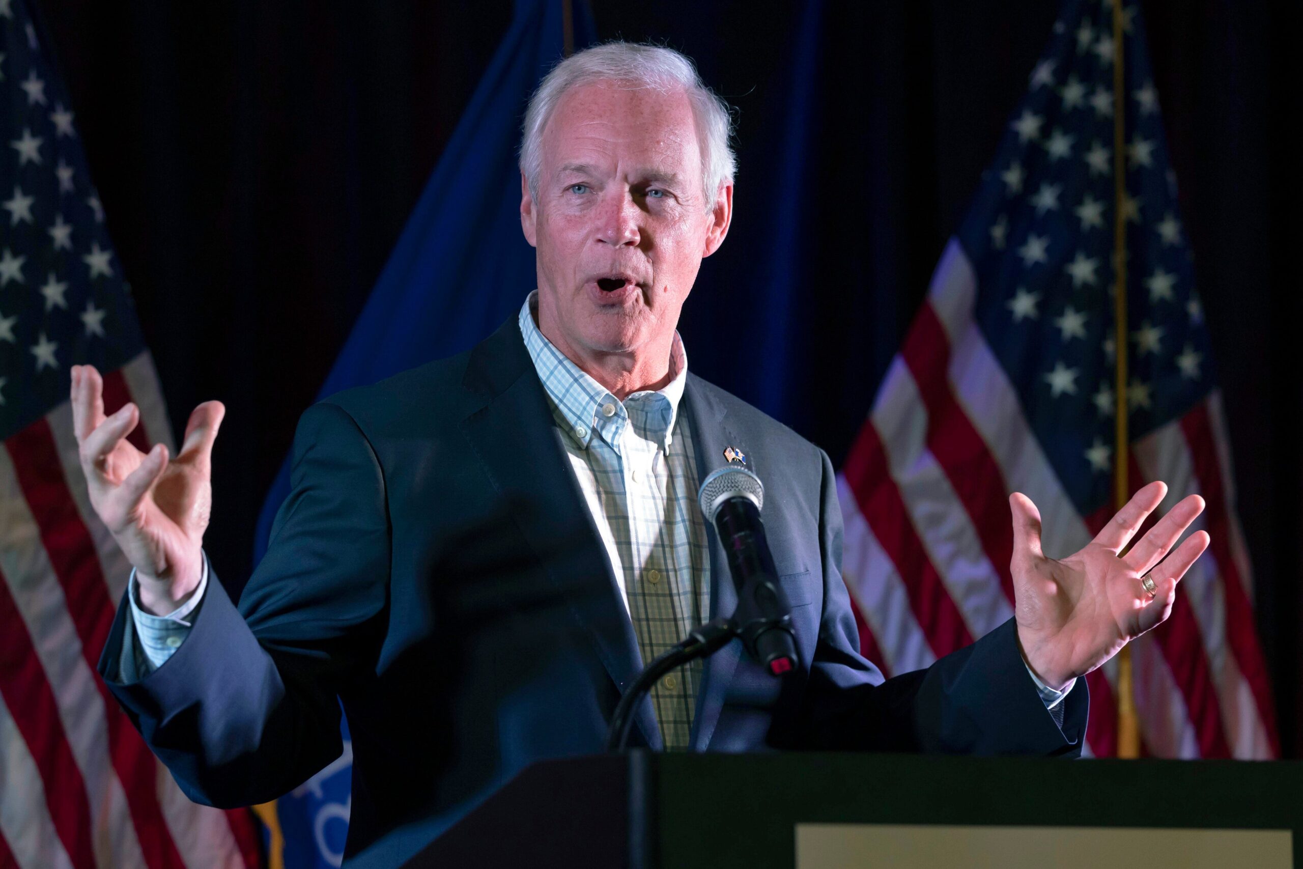 Ron Johnson speaks with his hands up at an election party