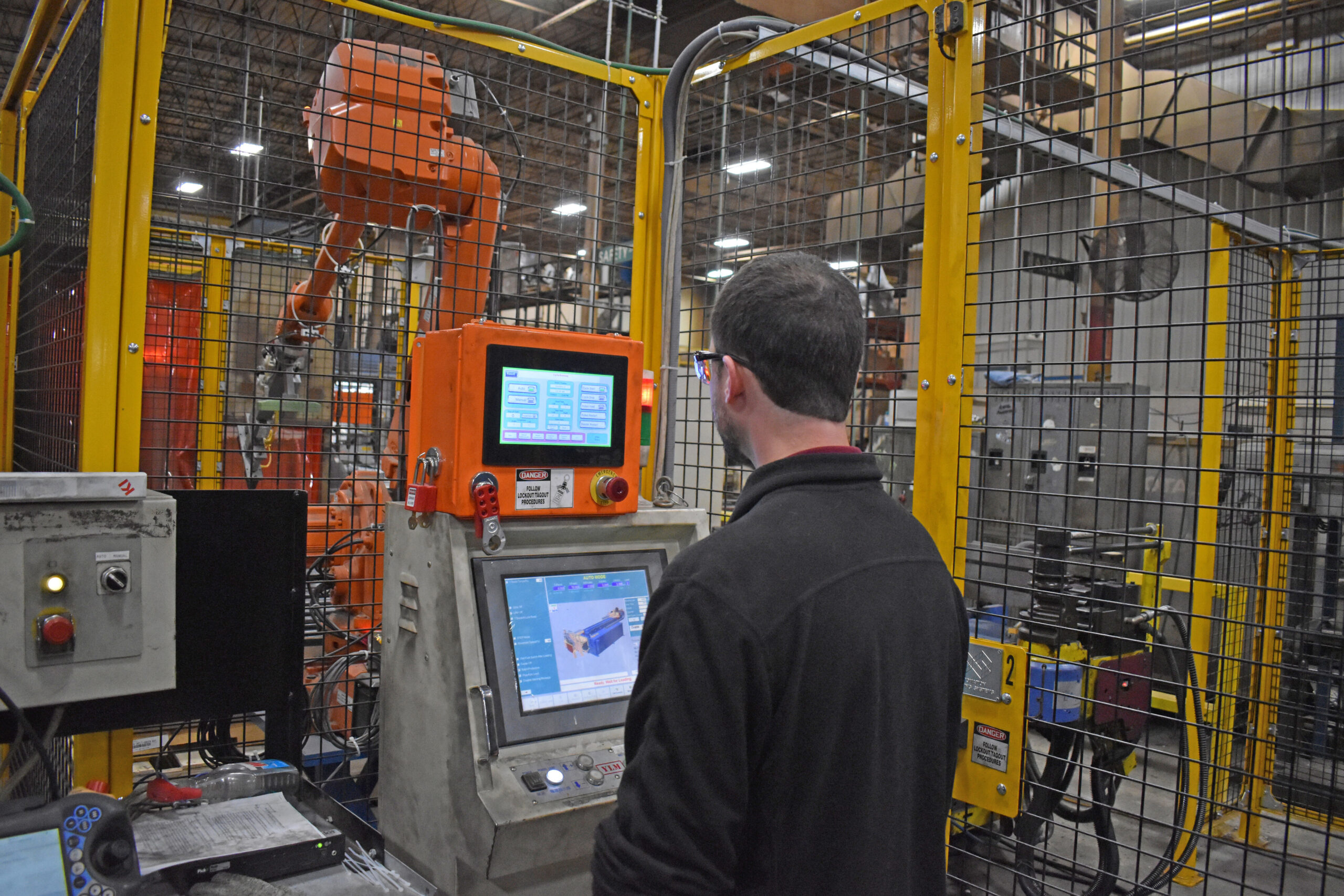 Alex Peters, automation engineering manager for Green Bay manufacturer KI, programs a computer on one of the company's machines.