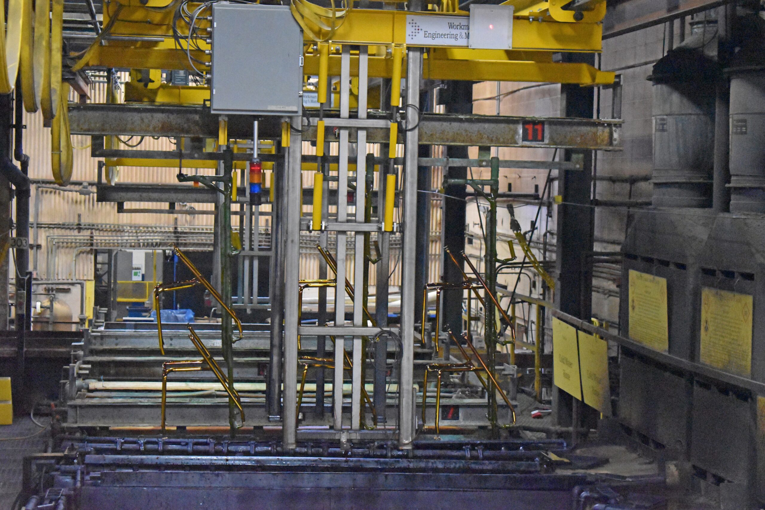 Frames for metal chairs are dunked into chemical tanks at manufacturer KI's Green Bay plant.