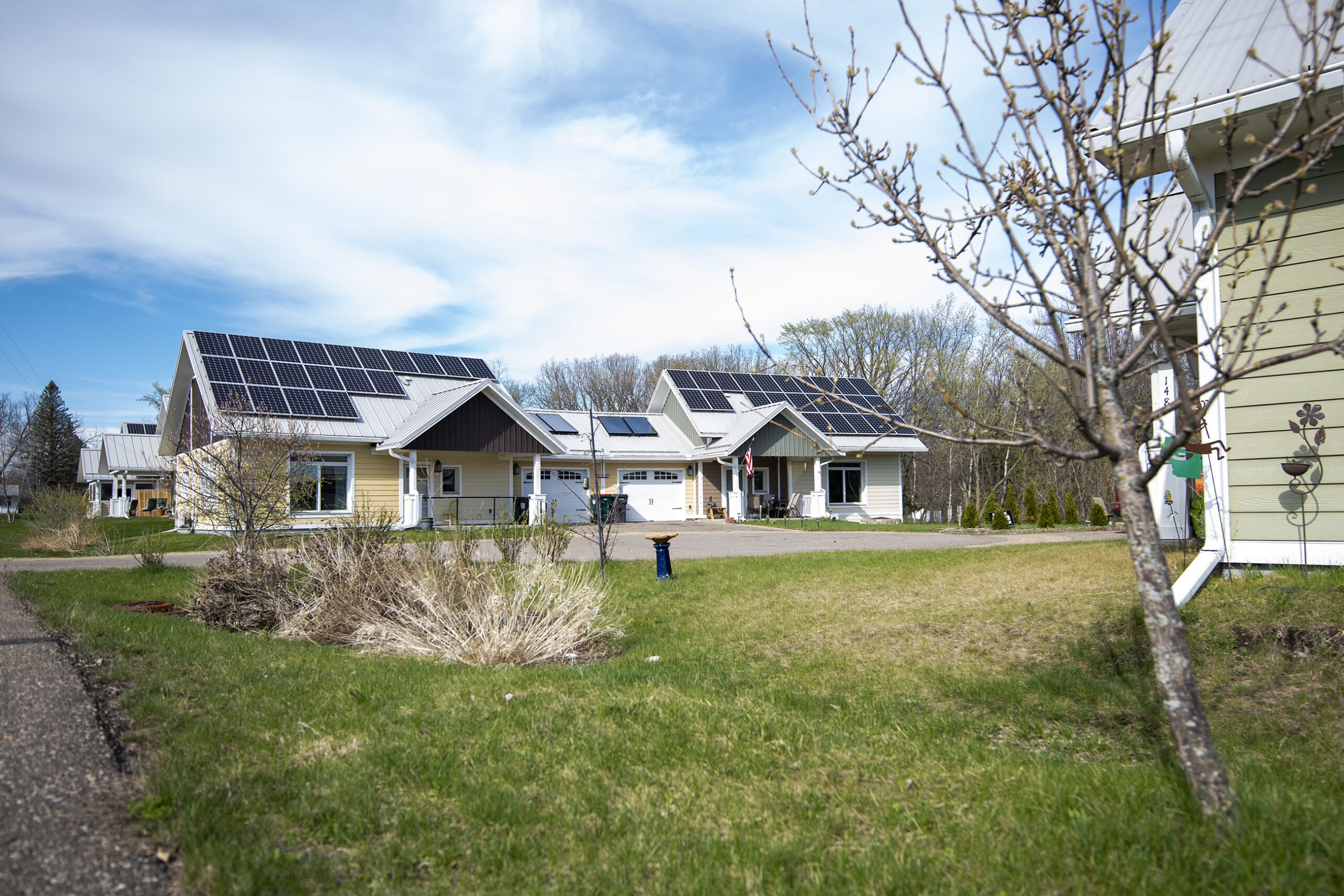 The roofs of two small homes are covered in solar panels.