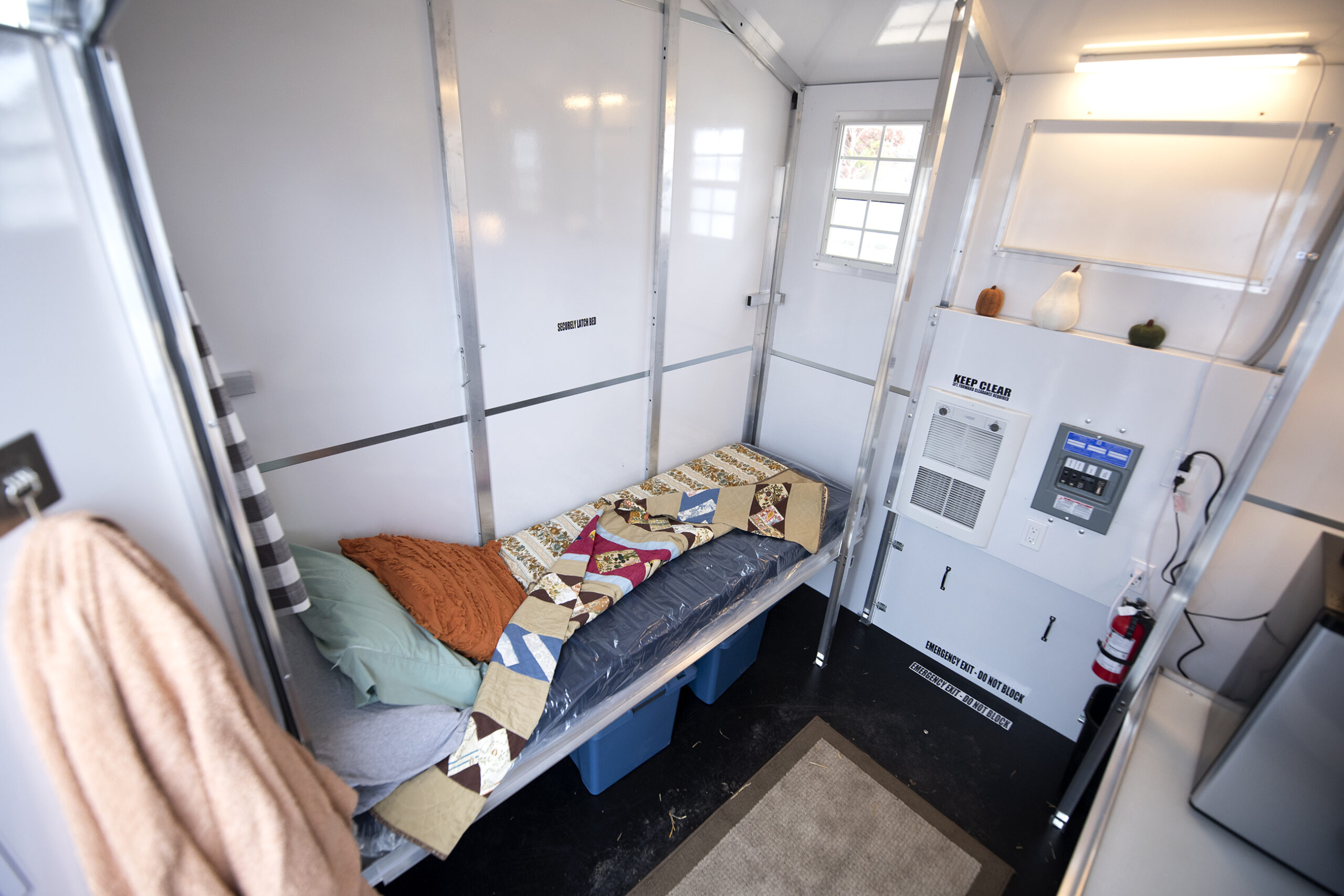 White walls surround a small white cot area where residents sleep.