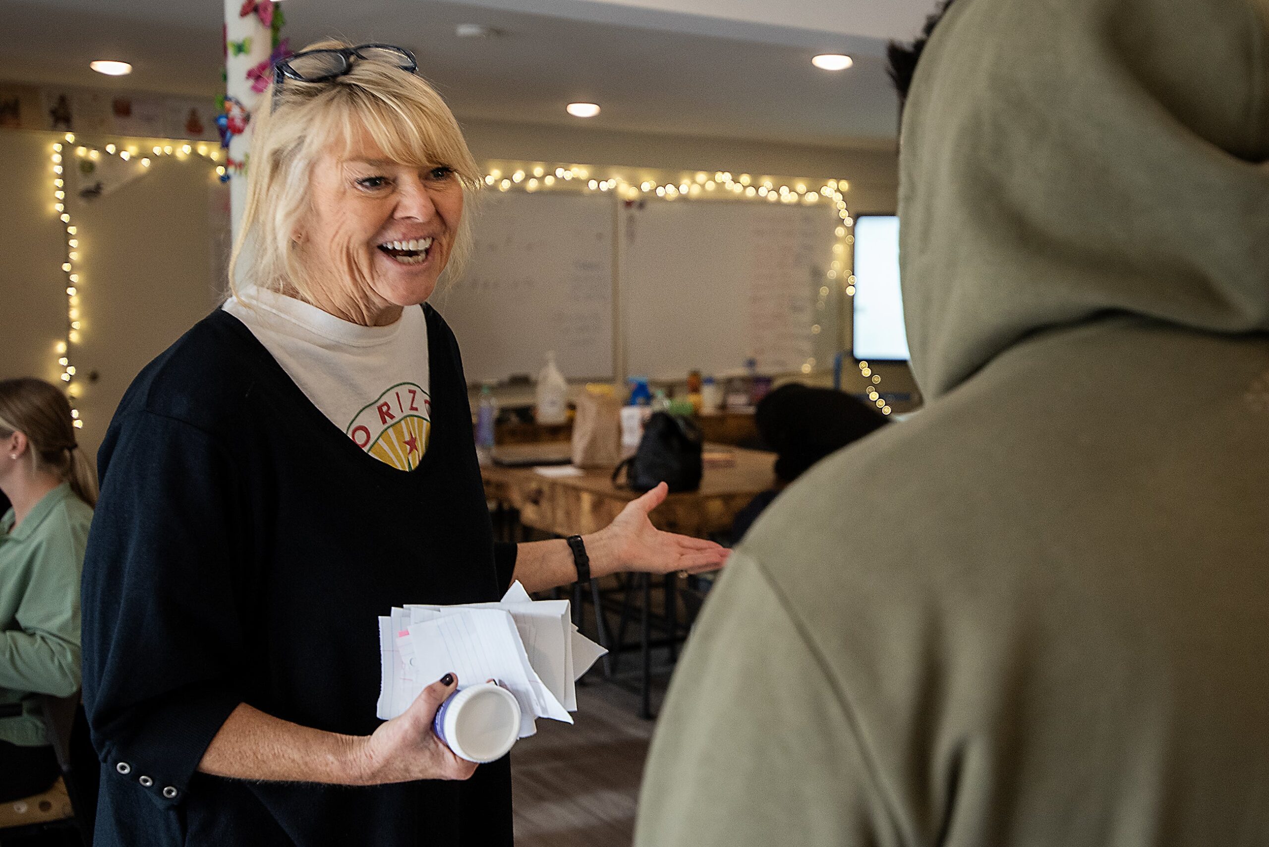 Traci Goll smiles as she speaks to a student in a classroom.