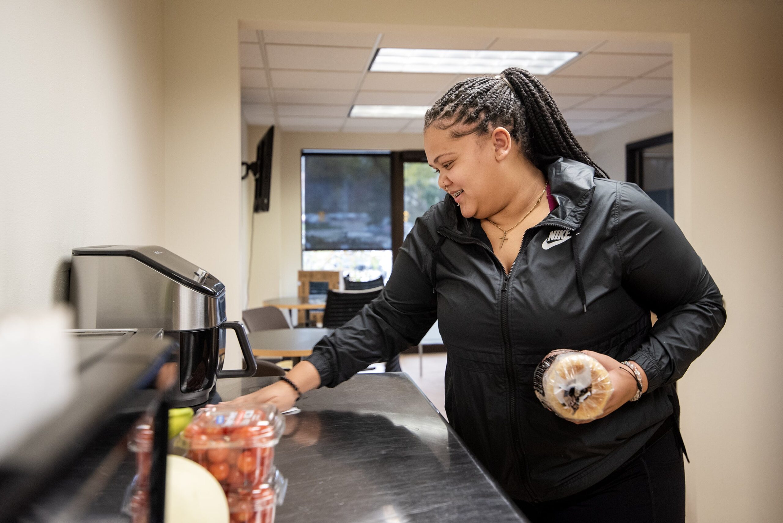 A student wipes a table with kitchen supplies on it.