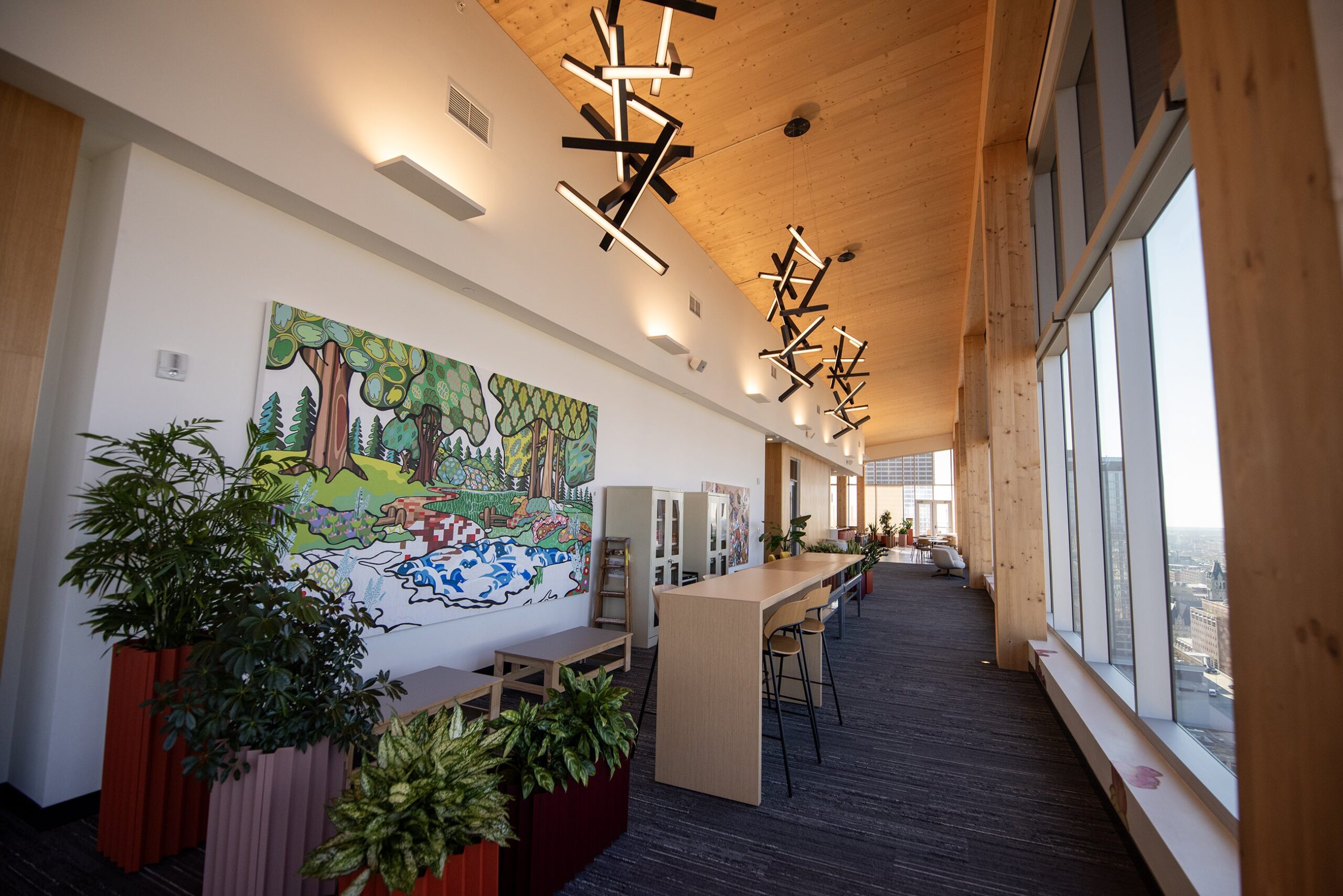 Wooden details can be seen on the ceiling and walls of a hallway. A large painting is also on the wall.