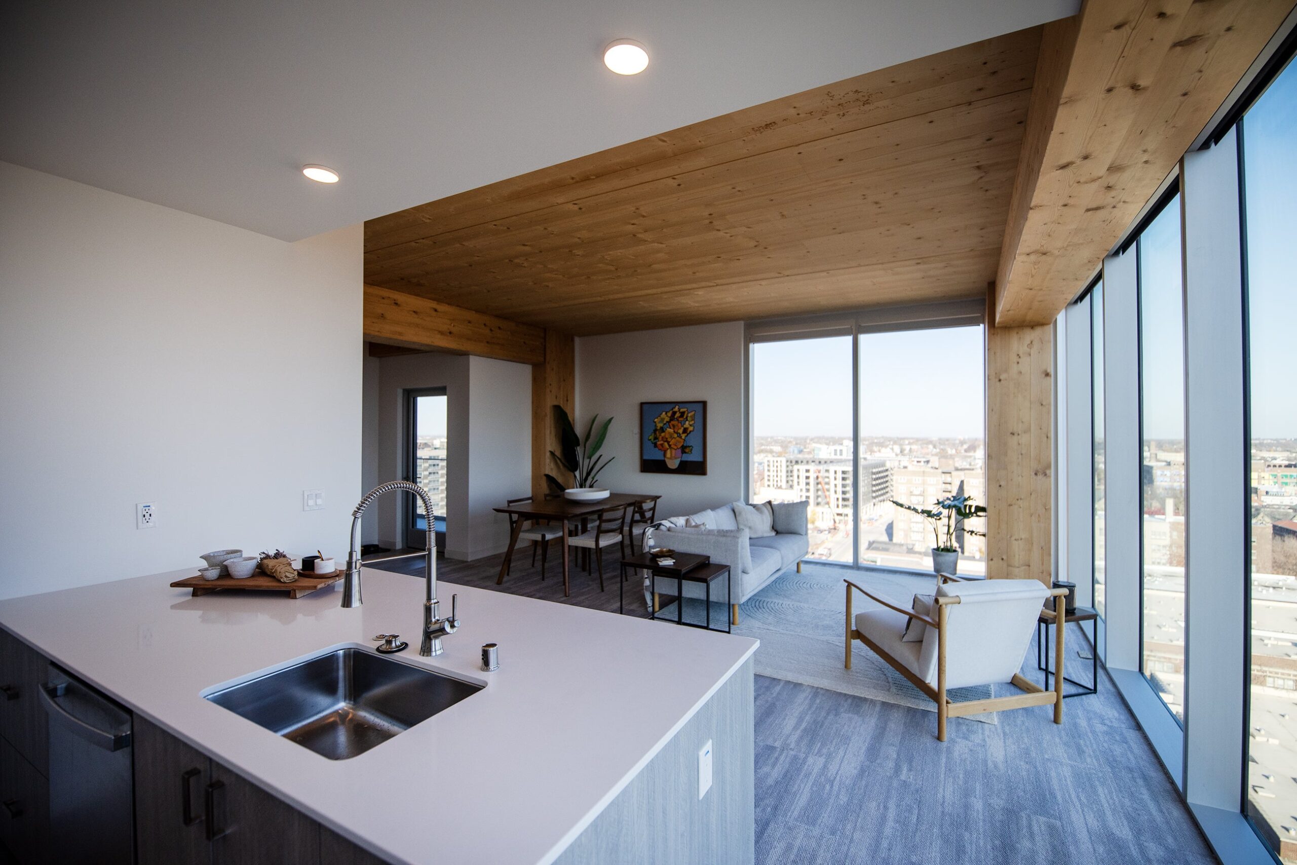 An apartment unit with large windows and wooden columns and ceilings.