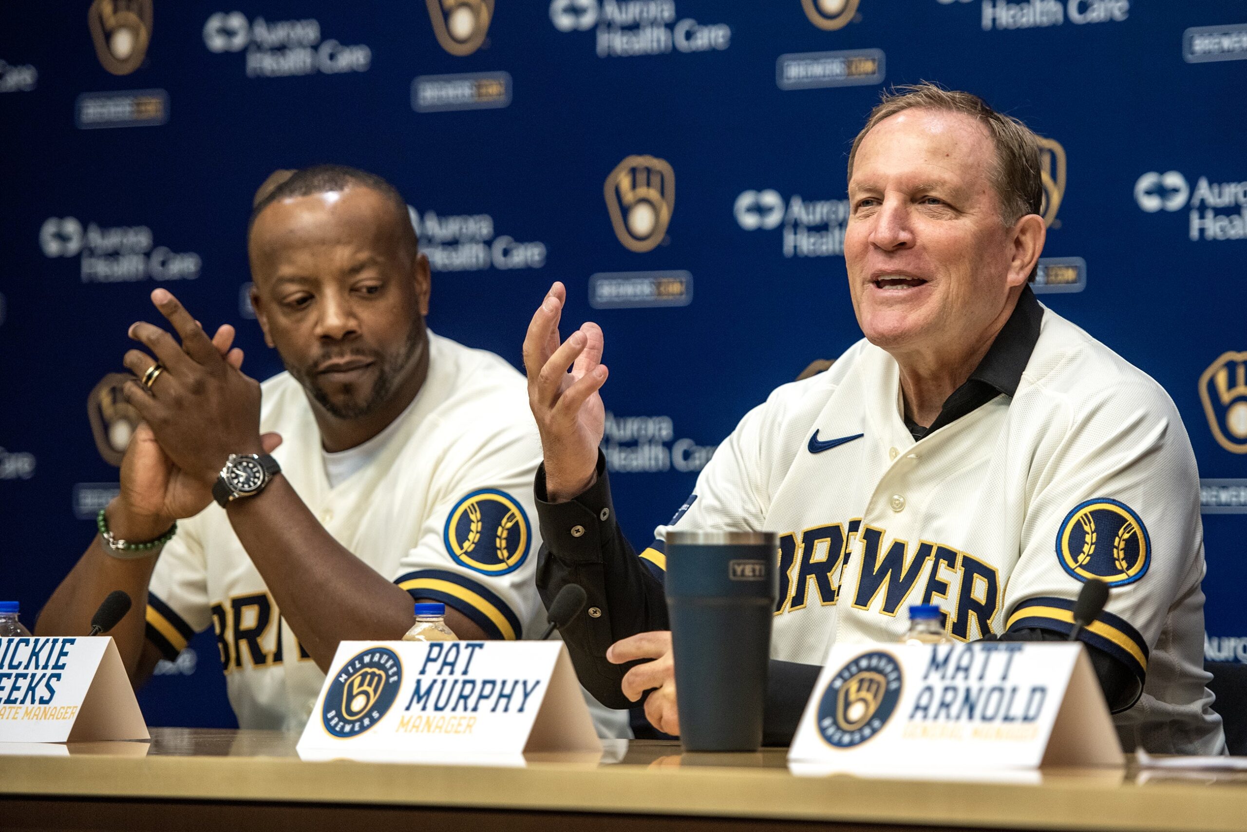 Pat Murphy gestures as he speaks while sitting alongside Rickie Weeks.