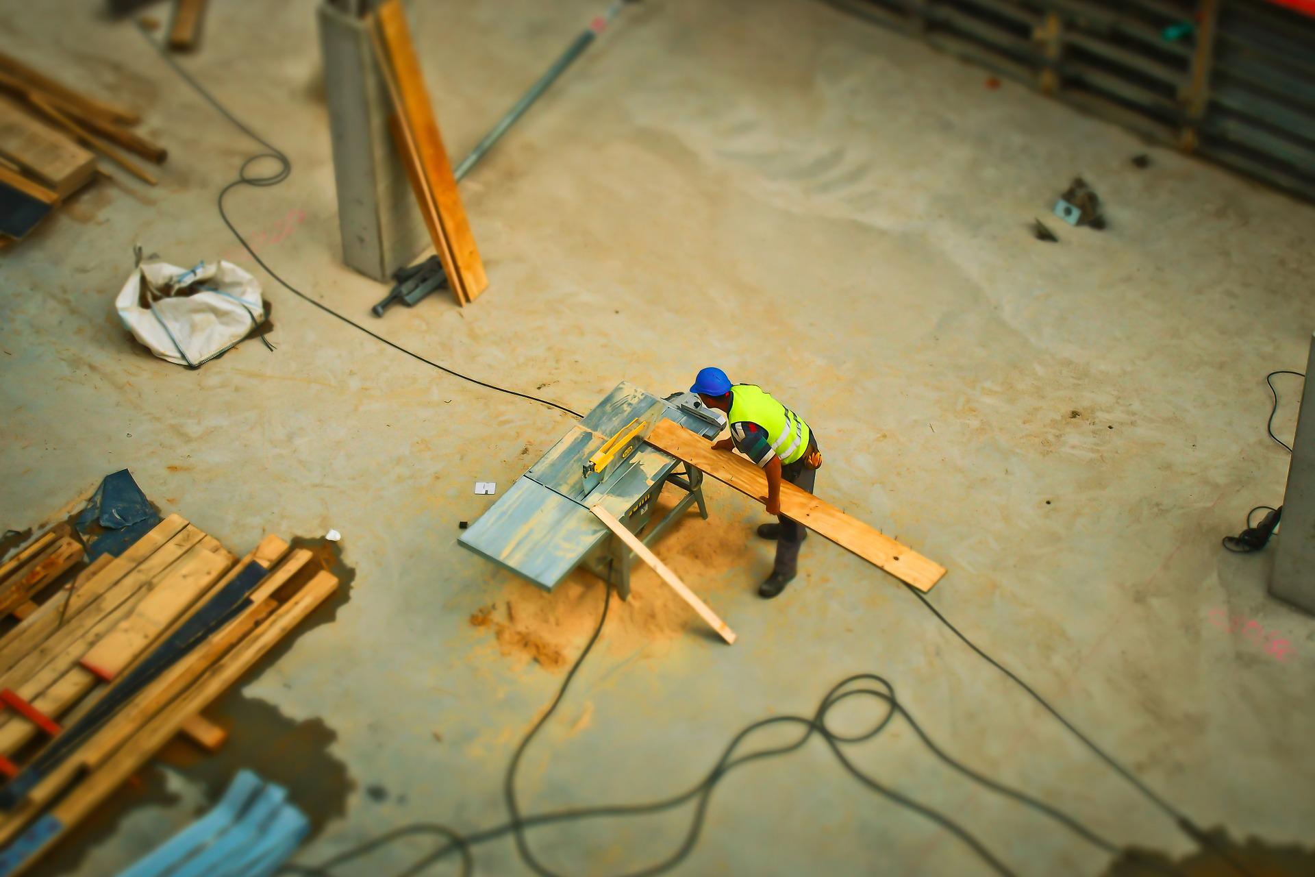 Worker using table saw on construction site.