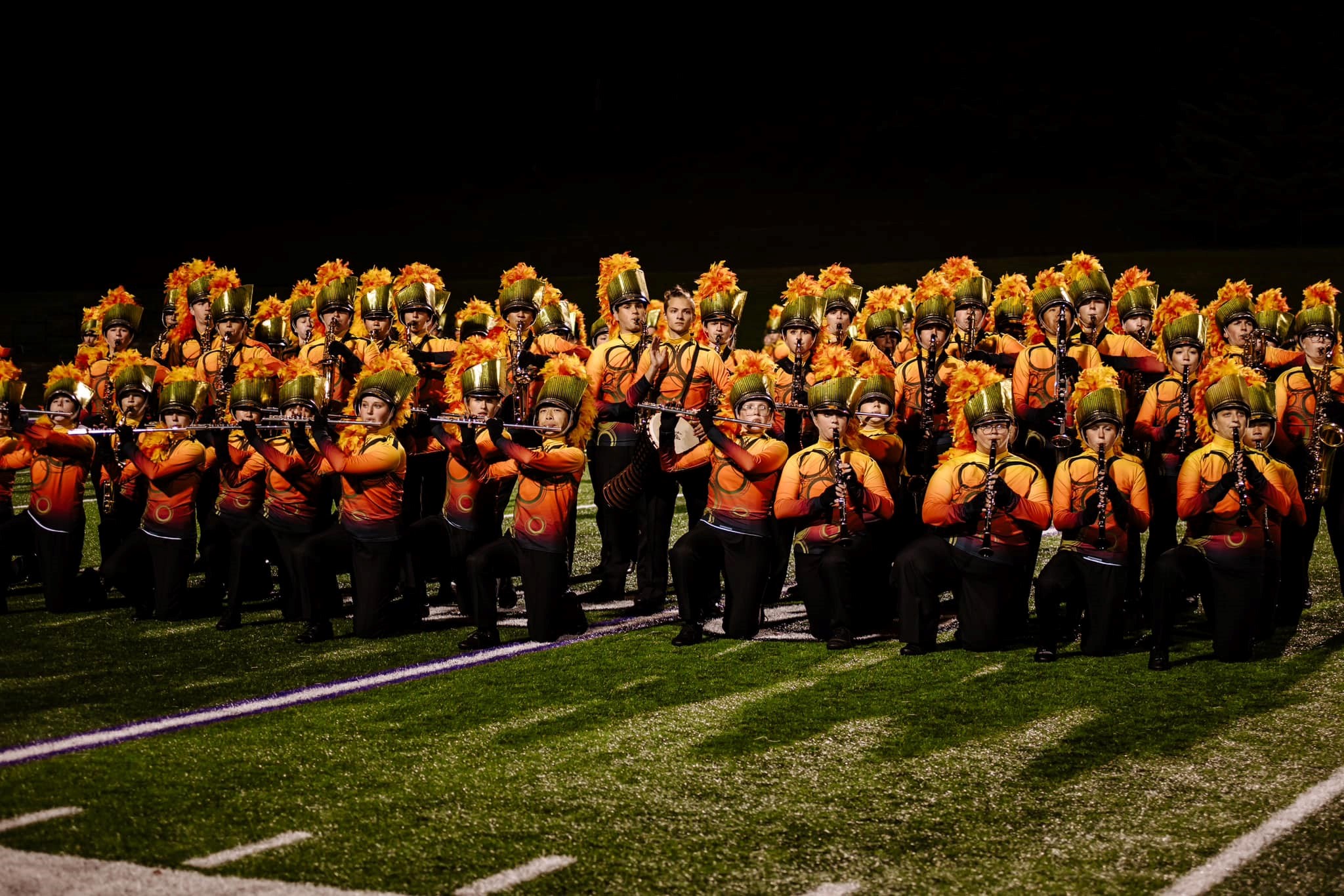 a marching band dressed in orange uniforms