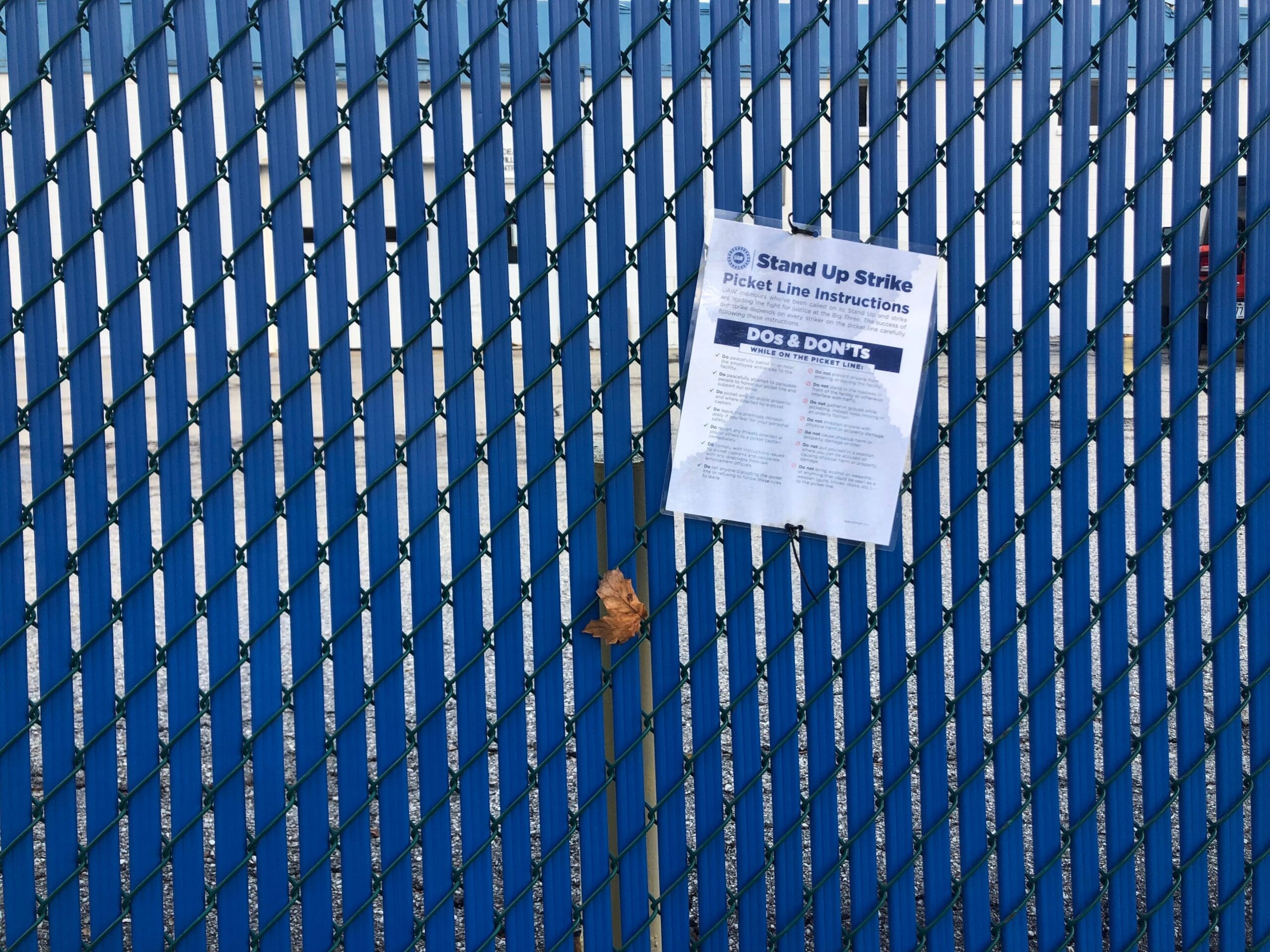 A document attached to a fence with 
