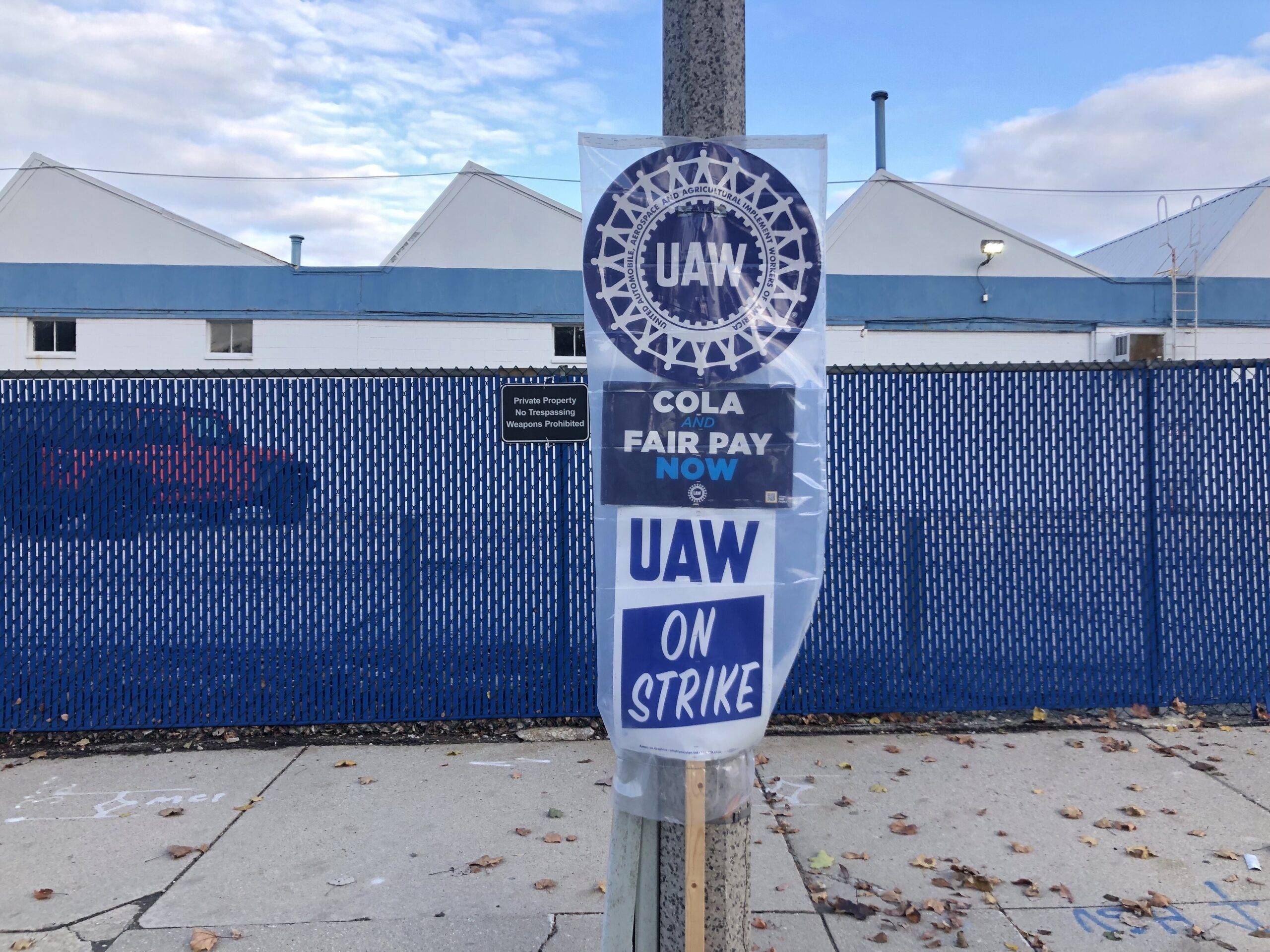 Signs attached to a pole saying "UAW on strike"