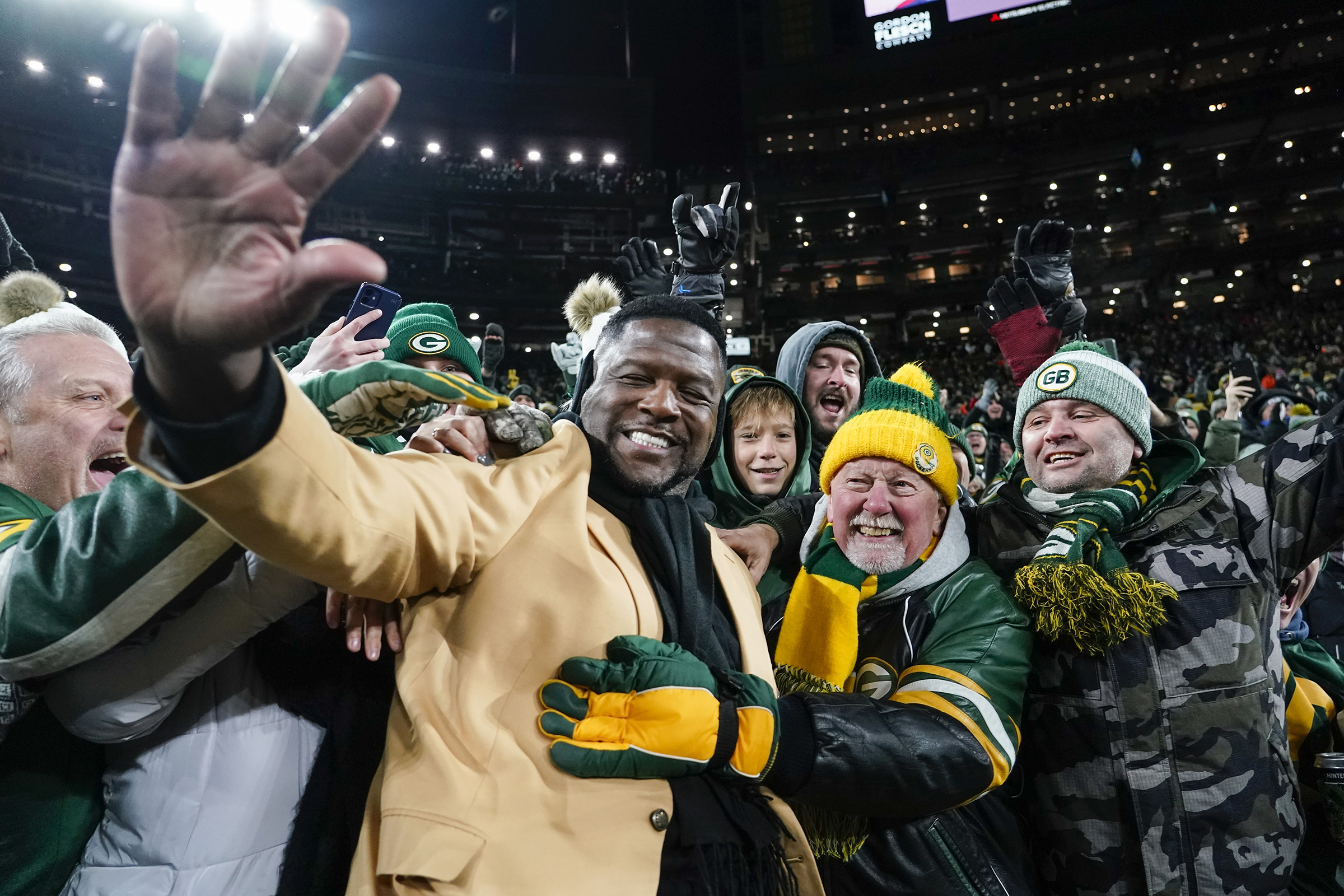 LeRoy Butler is embraced in the stands of Lambeau Field as he leaps from the field